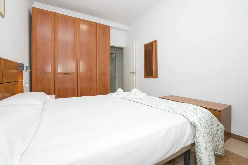 A bedroom with a large bed and wooden wardrobes.