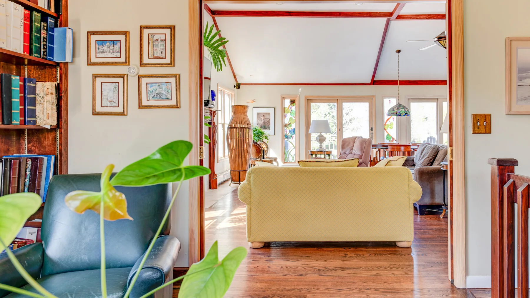 Una sala de estar con asientos, estanterías y cuadros enmarcados.