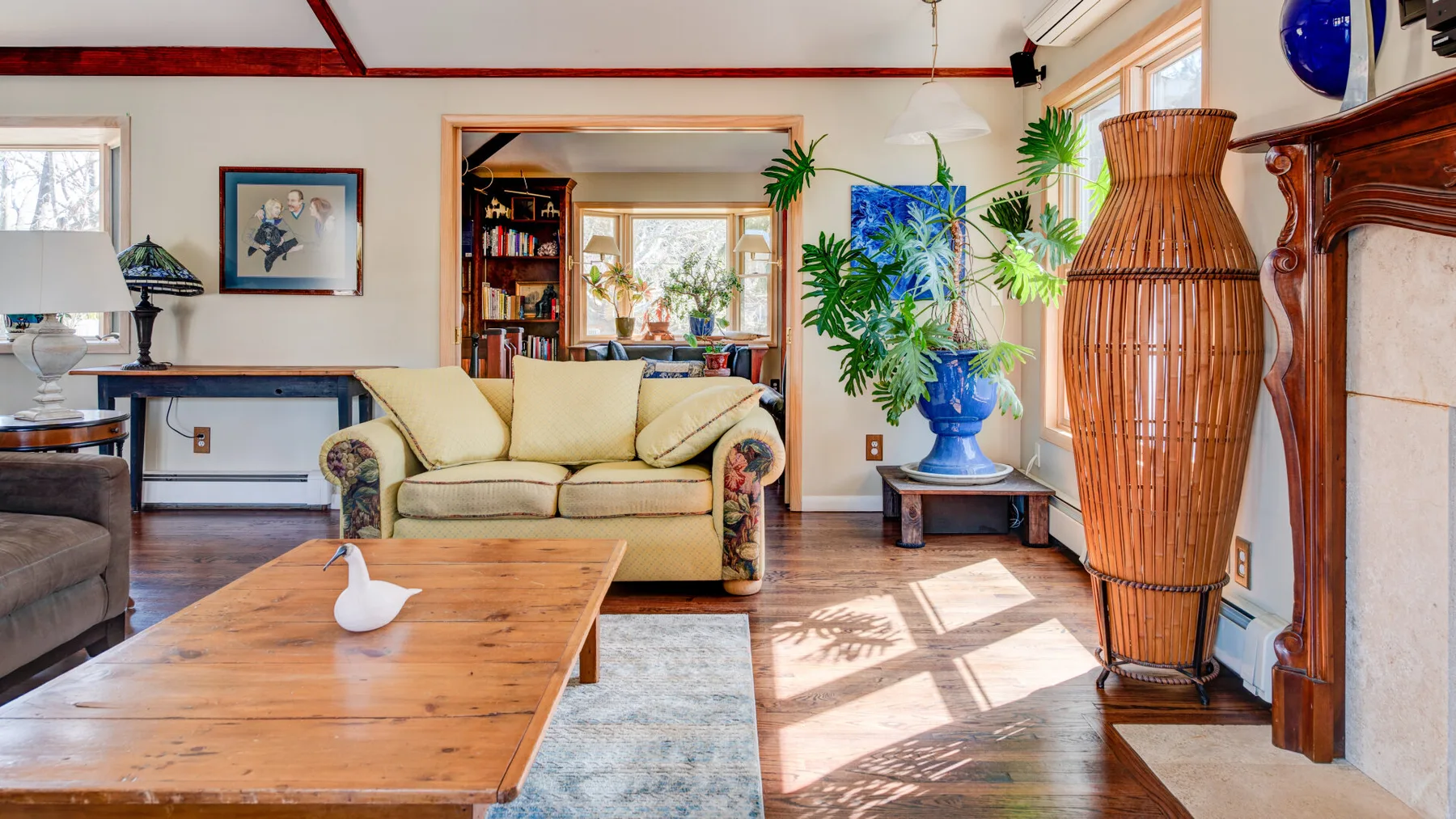 Una sala luminosa con un sofá claro y una mesa de centro de madera.