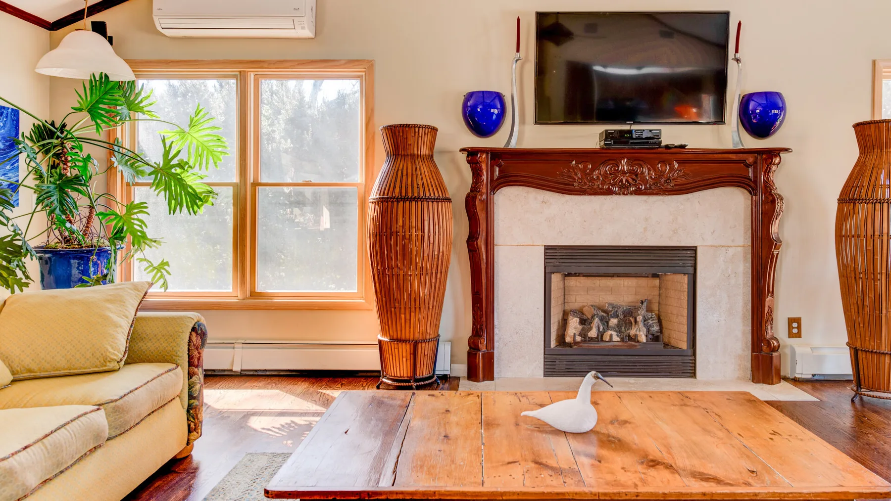 Una sala de estar con chimenea, asientos y una mesa baja de madera.