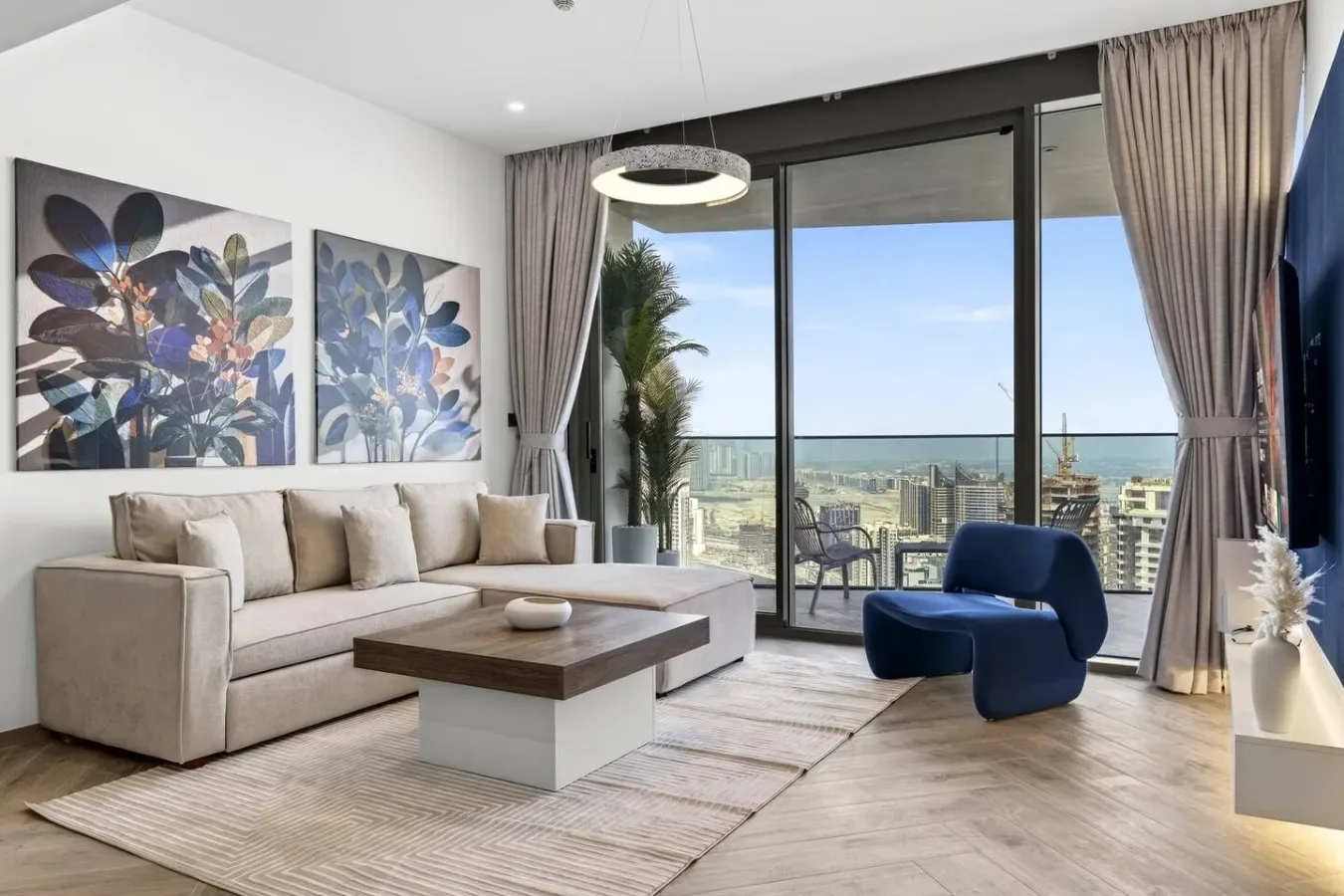 Una sala luminosa con asientos, una mesa de centro y grandes ventanales con vistas a la costa.