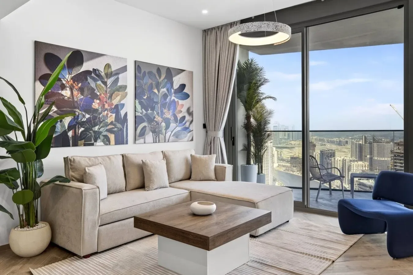 Una sala luminosa con asientos, una mesa de centro y grandes ventanales con vistas a la ciudad.