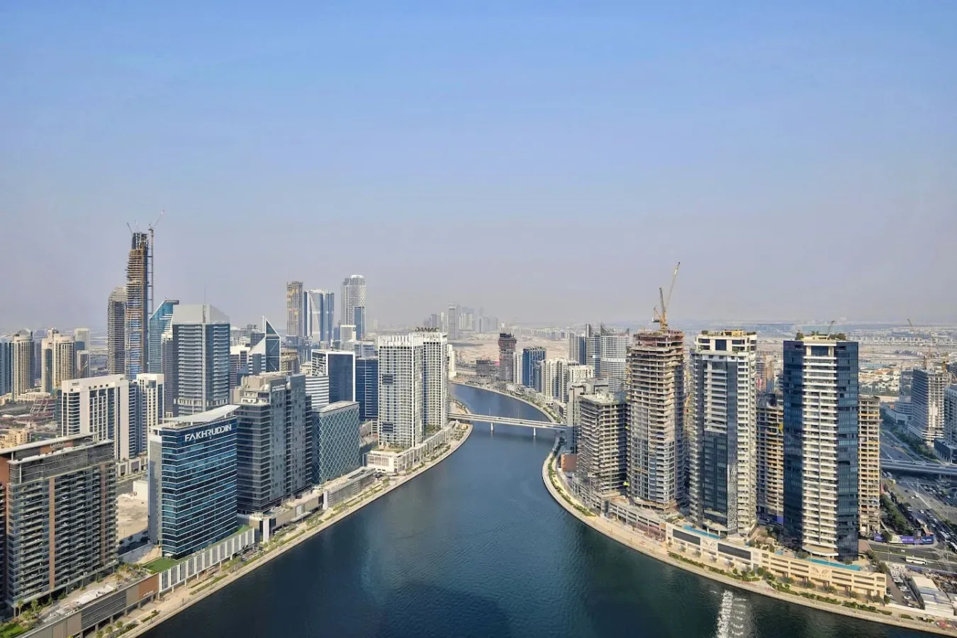 Un horizonte urbano de edificios altos bordea un canal sinuoso.