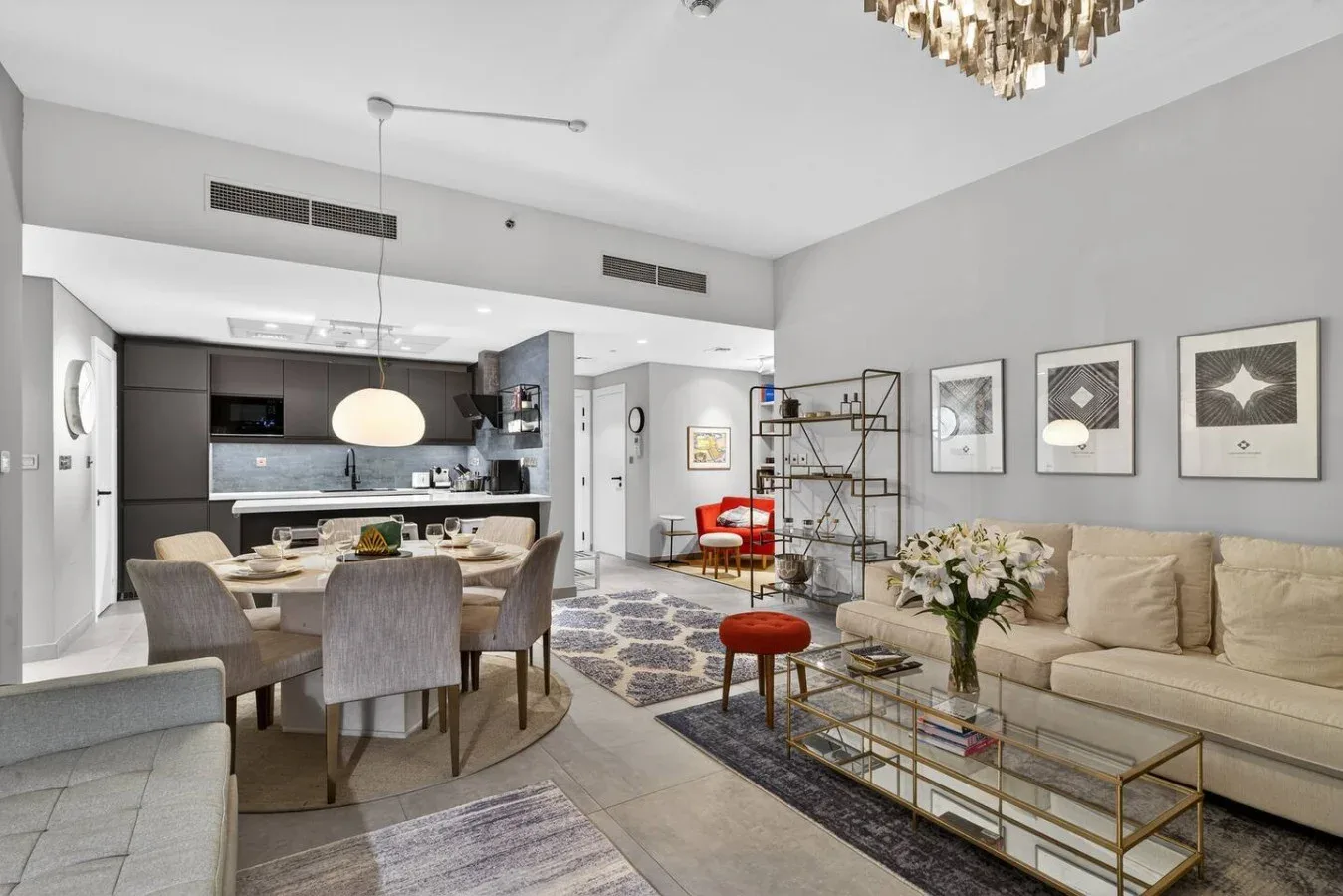Sala y comedor de concepto abierto con zona de estar beige y cocina.