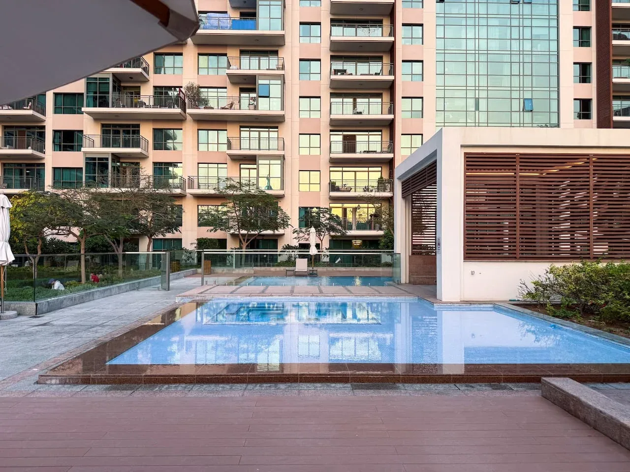 Una piscina al aire libre junto a un moderno edificio de apartamentos.