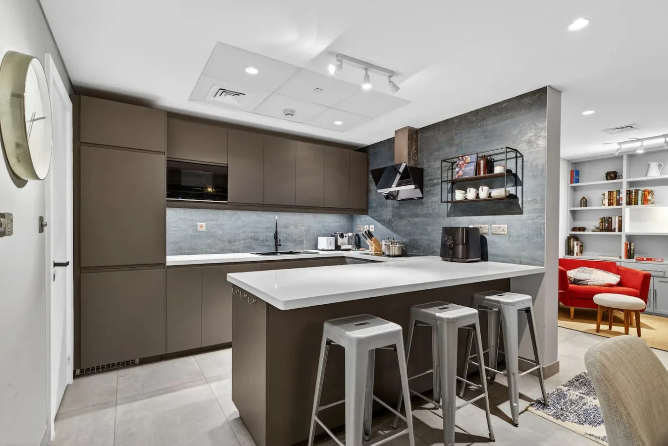Una cocina moderna con una isla grande y varios taburetes.