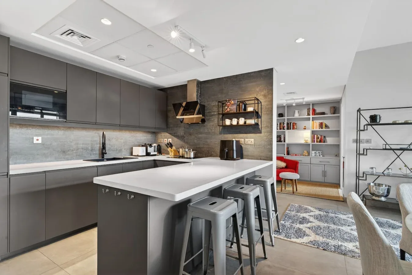 Una cocina moderna con una isla central y estanterías abiertas.