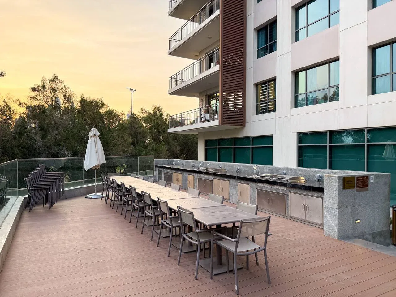 Terraza de comedor al aire libre junto a un edificio moderno, con mesas y asientos.