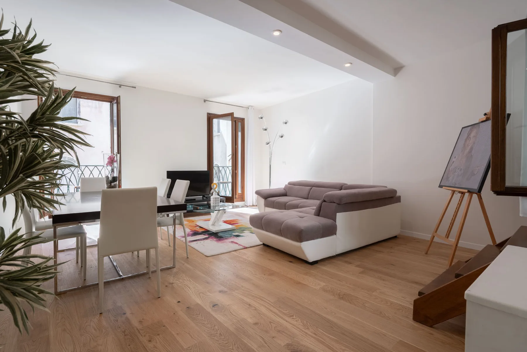Una sala luminosa con asientos, una mesa de comedor y una ventana grande.