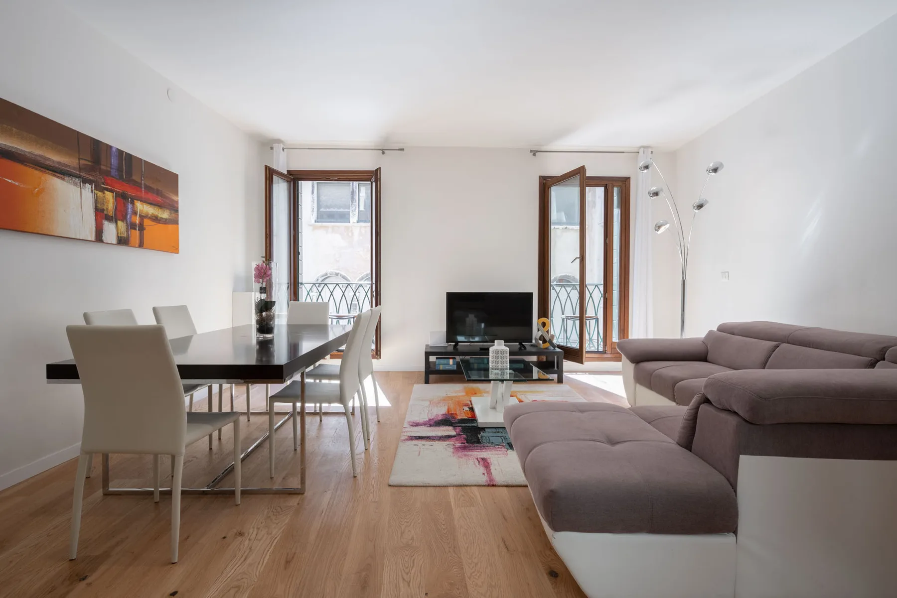 Una luminosa sala de estar y comedor con un sofá seccional y una mesa de comedor.