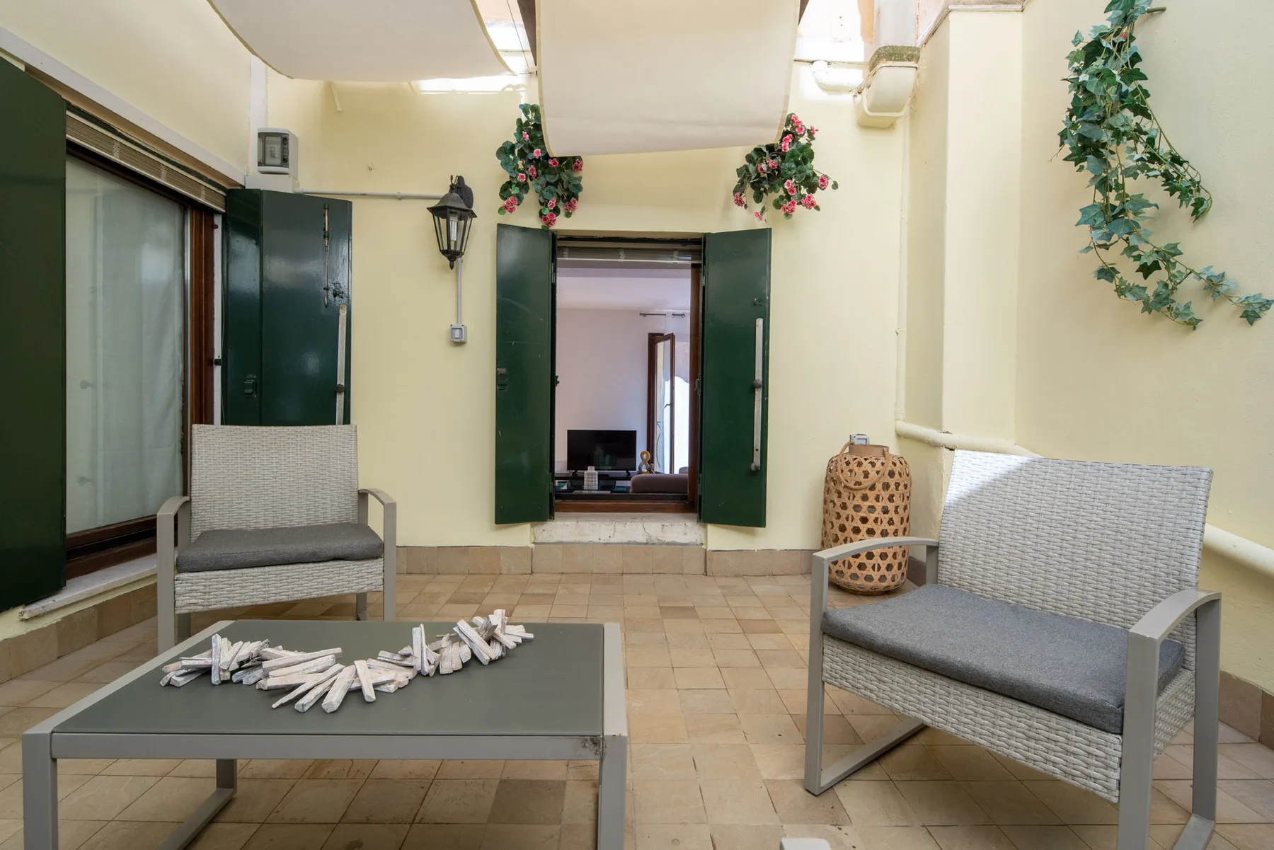 A tiled indoor seating area with chairs and a low table.