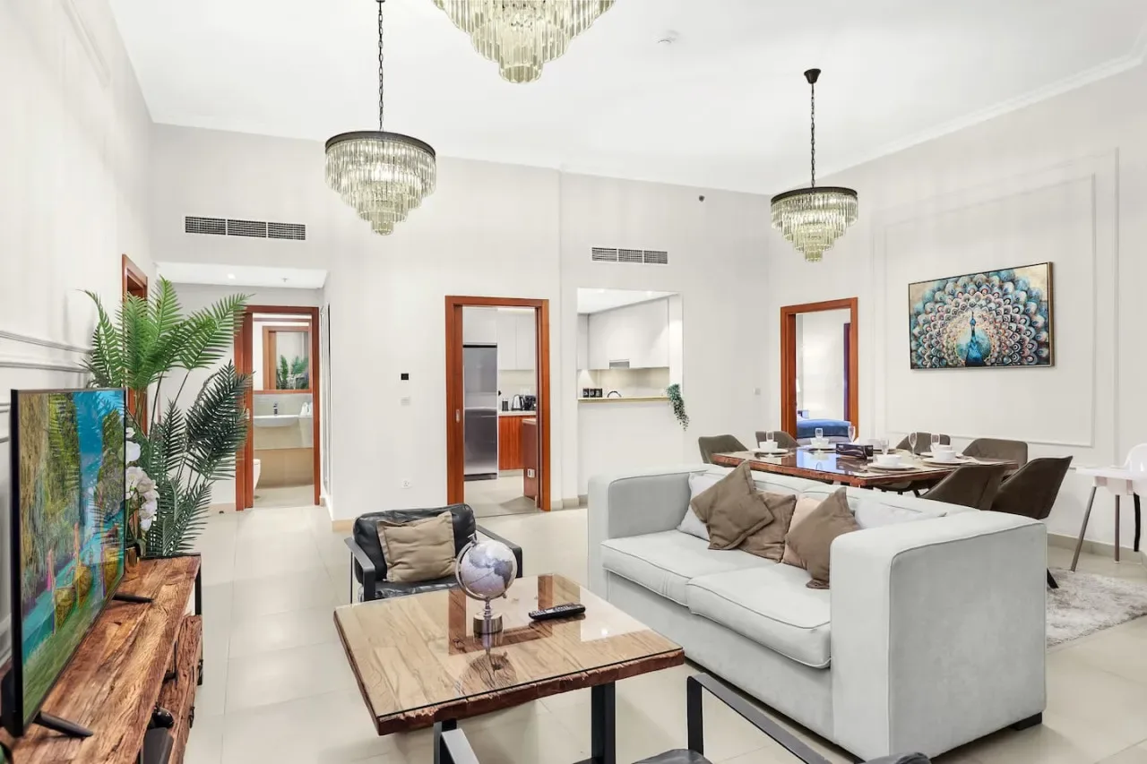 Una sala luminosa con un sofá blanco y una mesa de centro de madera.