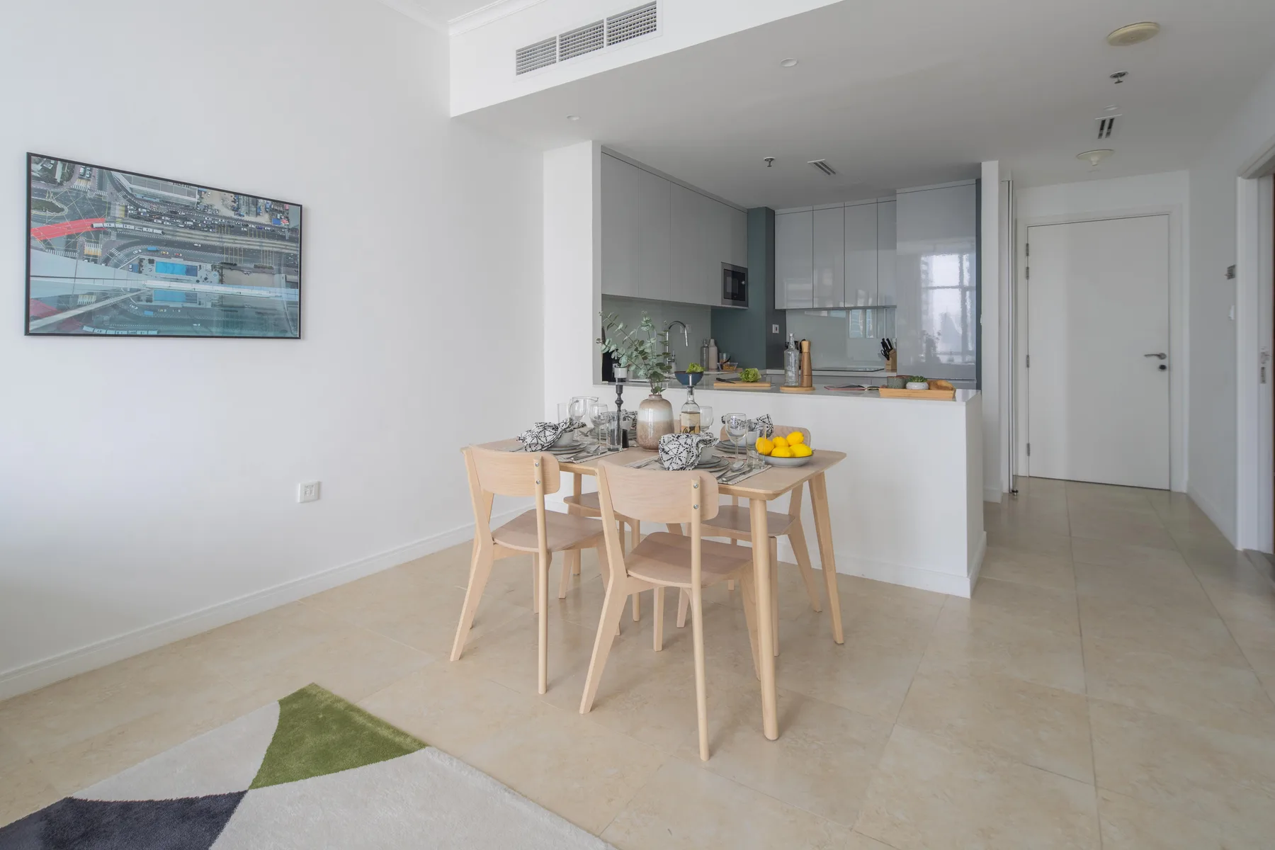 Un comedor con mesa y sillas está junto a una cocina abierta.