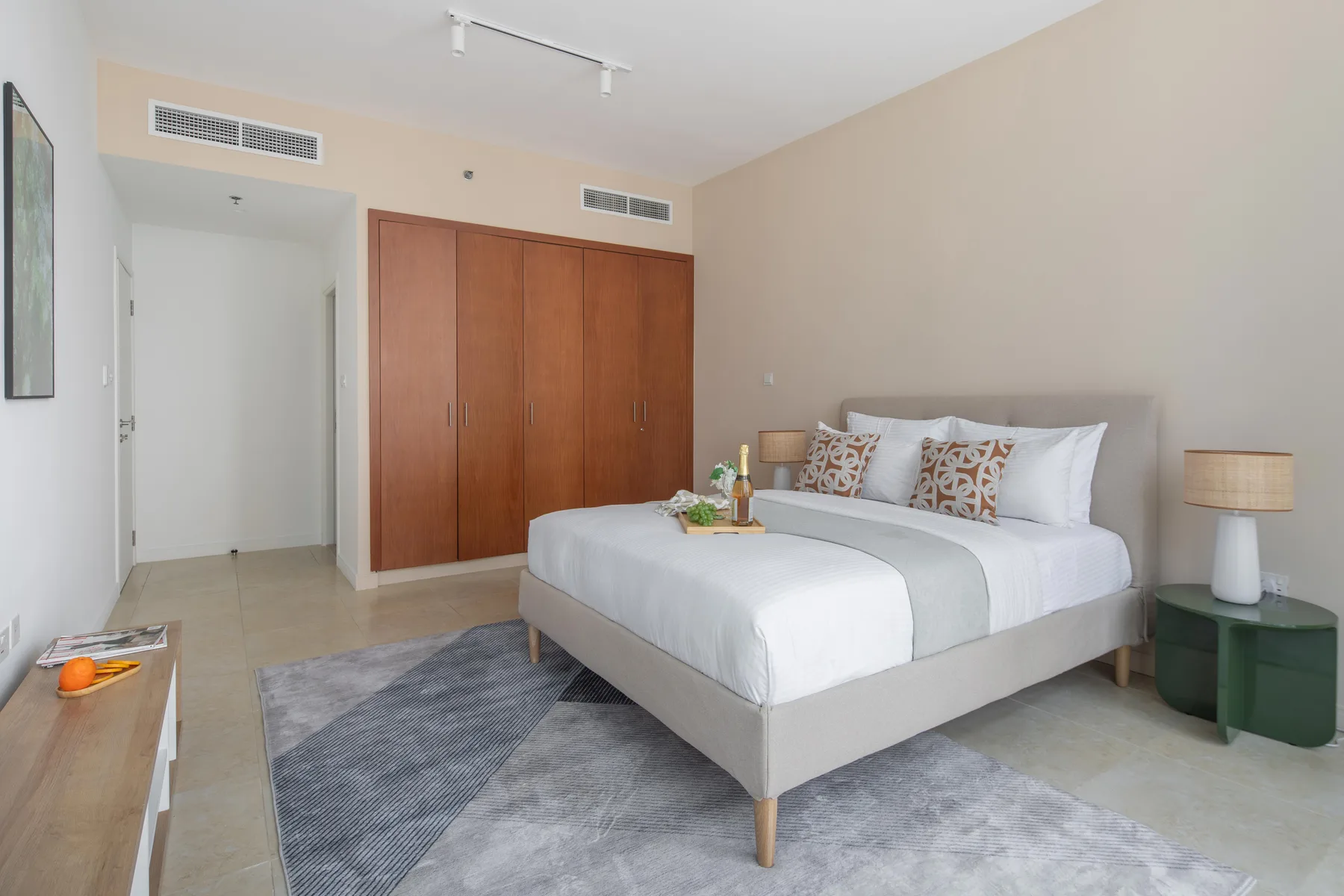 Un dormitorio con una cama grande, puertas de armario de madera y una mesita de noche.