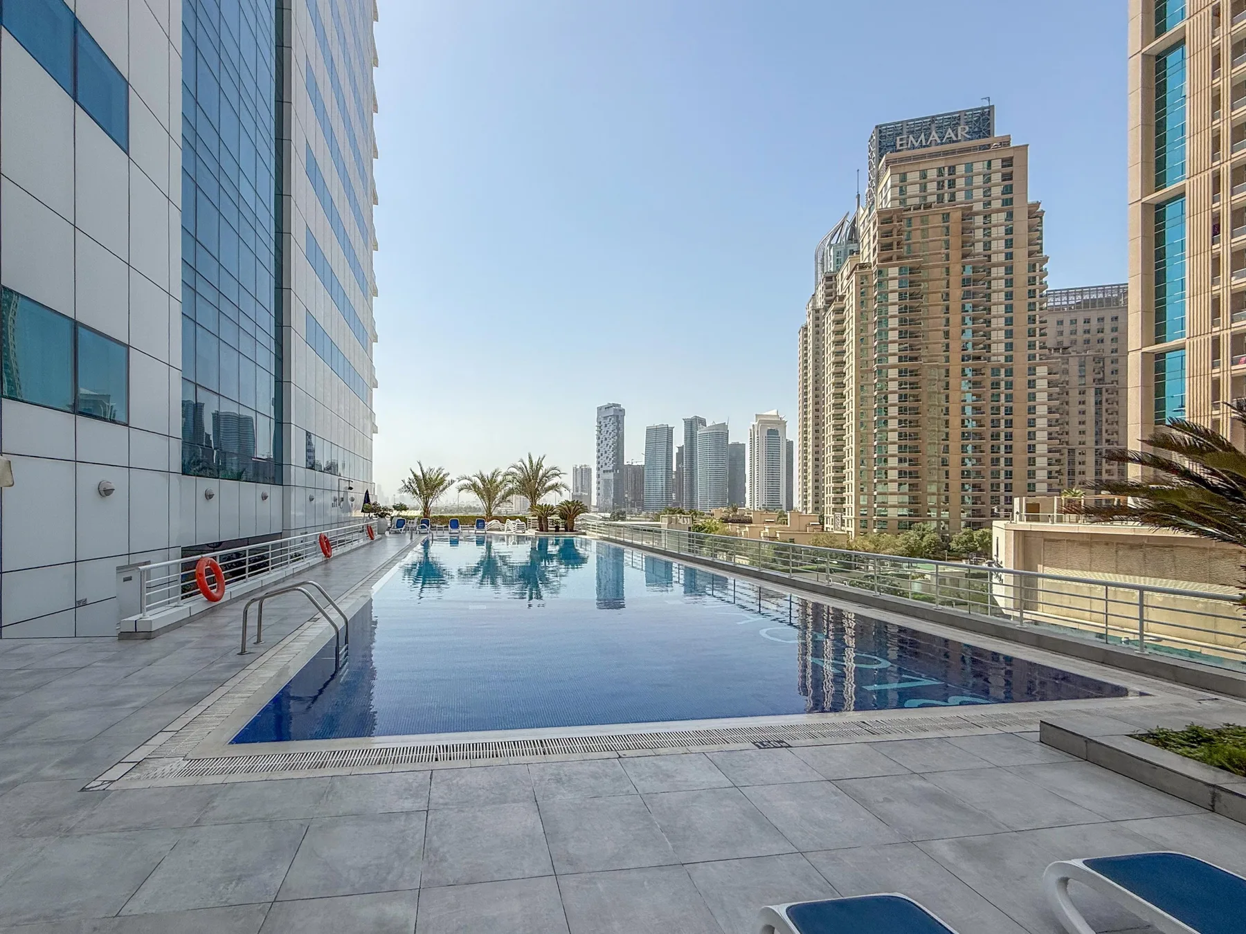 Una piscina en la azotea está rodeada de modernos edificios altos.