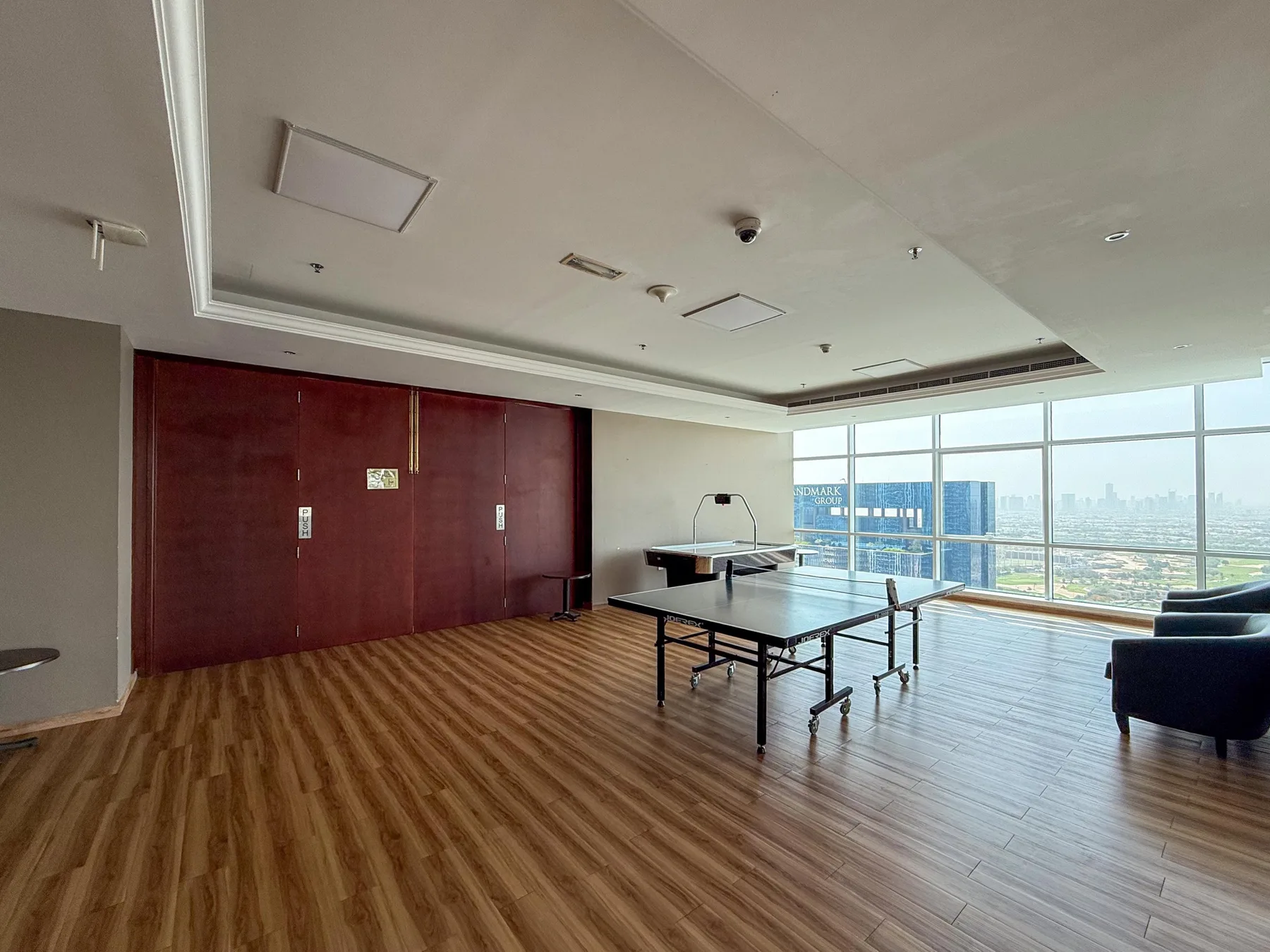 Una amplia sala de reuniones con una mesa, asientos y grandes ventanas.