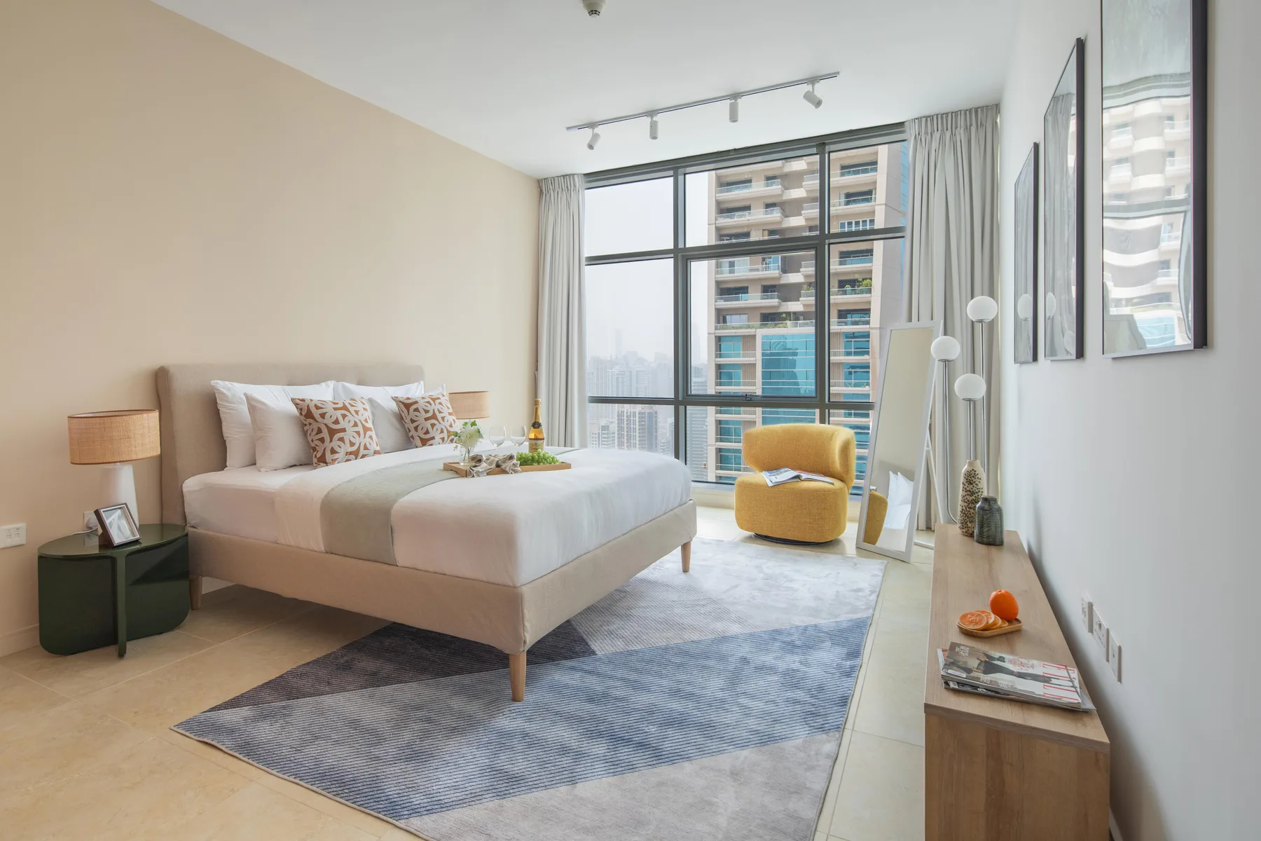 Un dormitorio luminoso con una cama grande junto a ventanas de piso a techo.