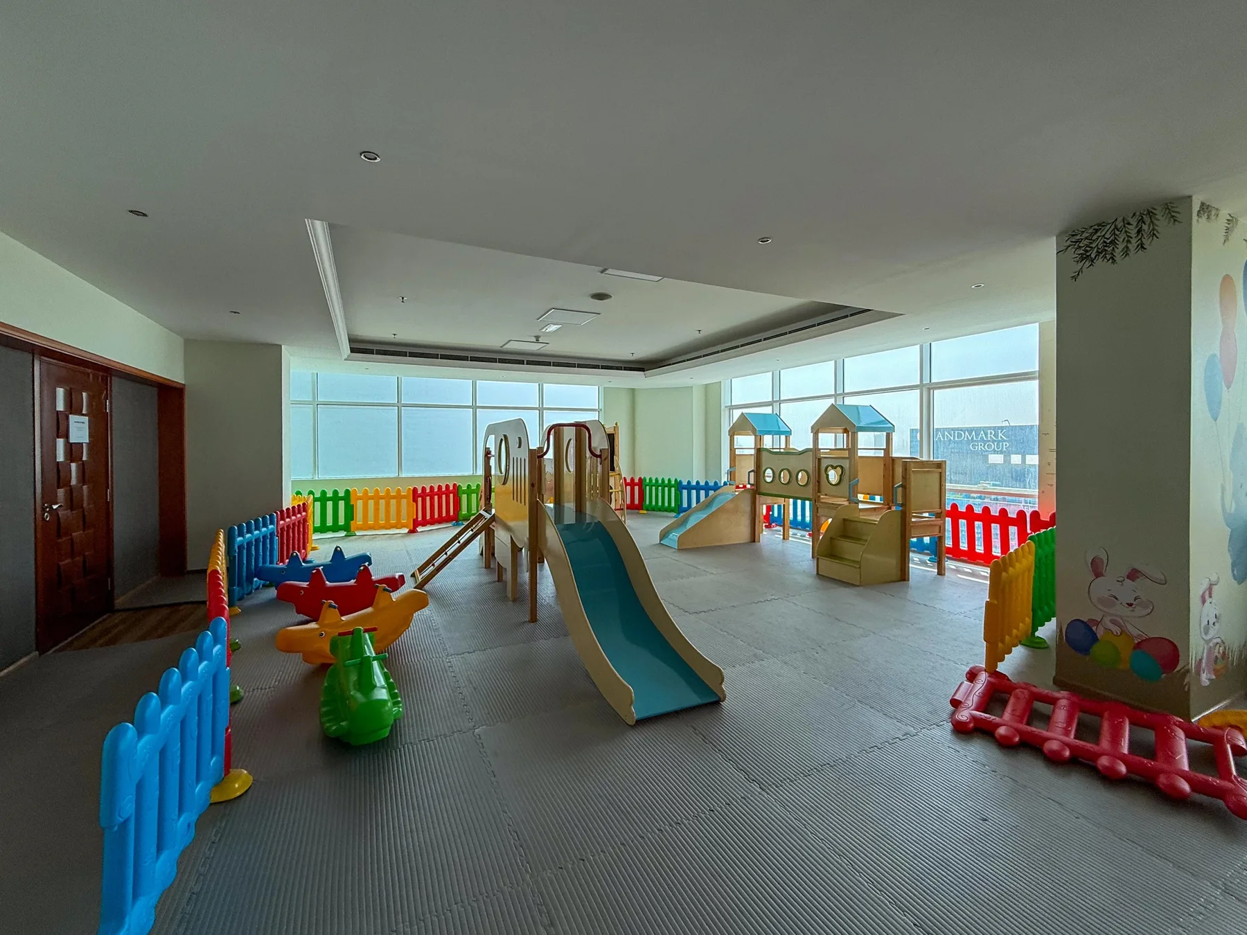 Un área de juegos infantil interior con toboganes y juegos de colores.
