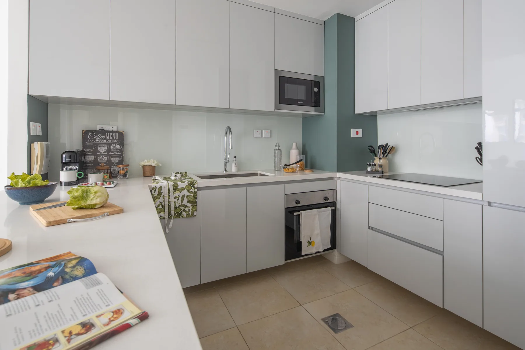 Una cocina moderna con gabinetes blancos, encimeras y un horno.