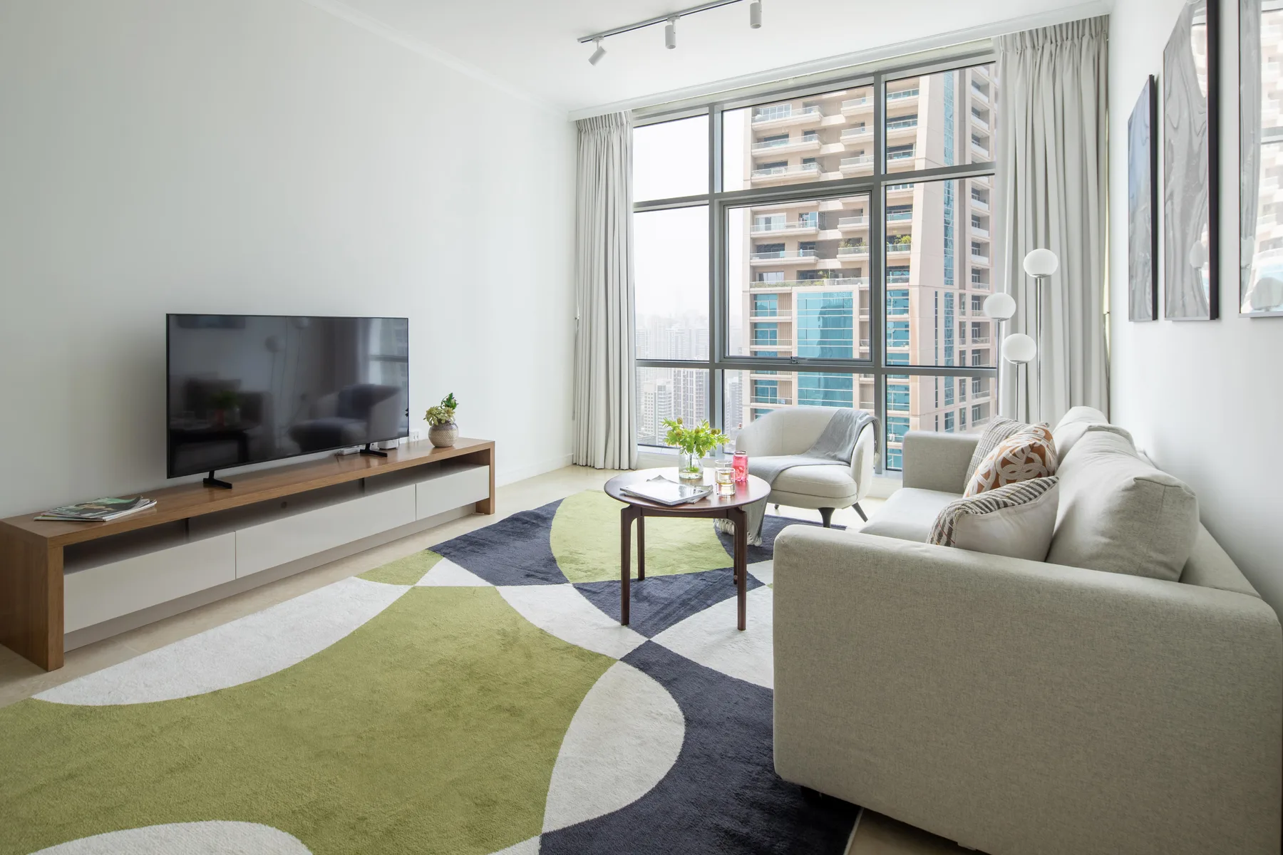 Una sala luminosa con asientos alrededor de una mesa de centro junto a grandes ventanas.