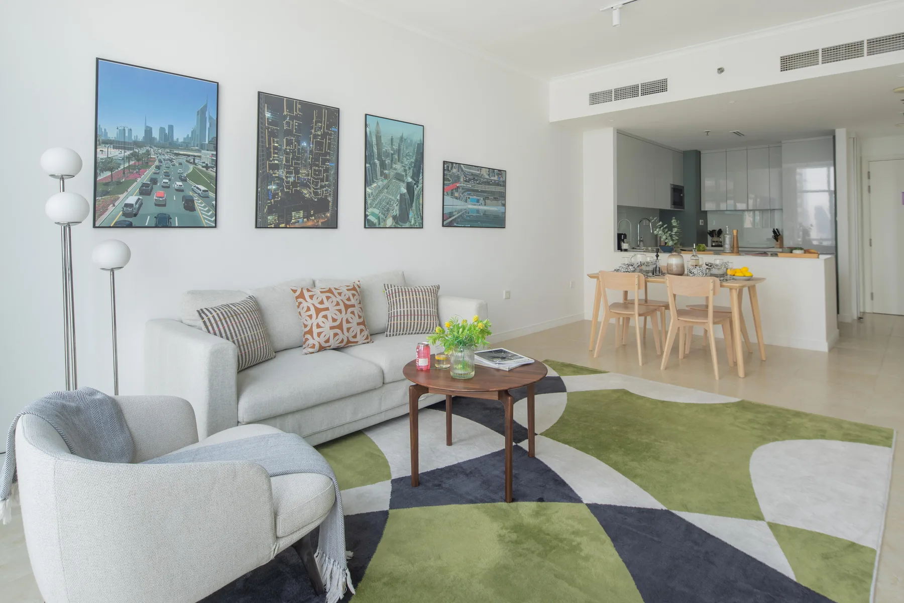Una luminosa sala de estar con sofá, sillón y zona de comedor.