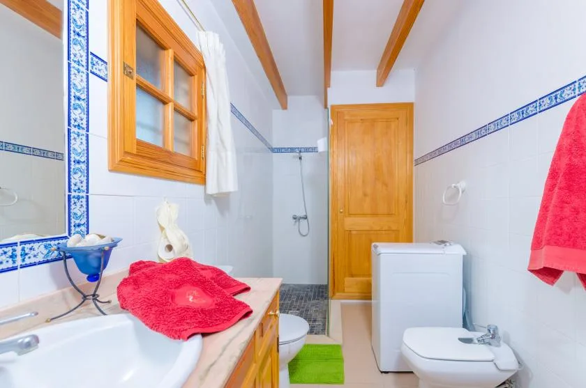 A tiled bathroom with a bathtub, toilet, and wooden door.