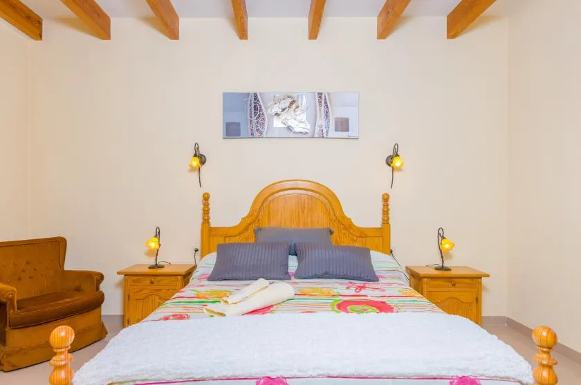 A bedroom with a wooden bed, colorful bedding, and matching bedside tables.