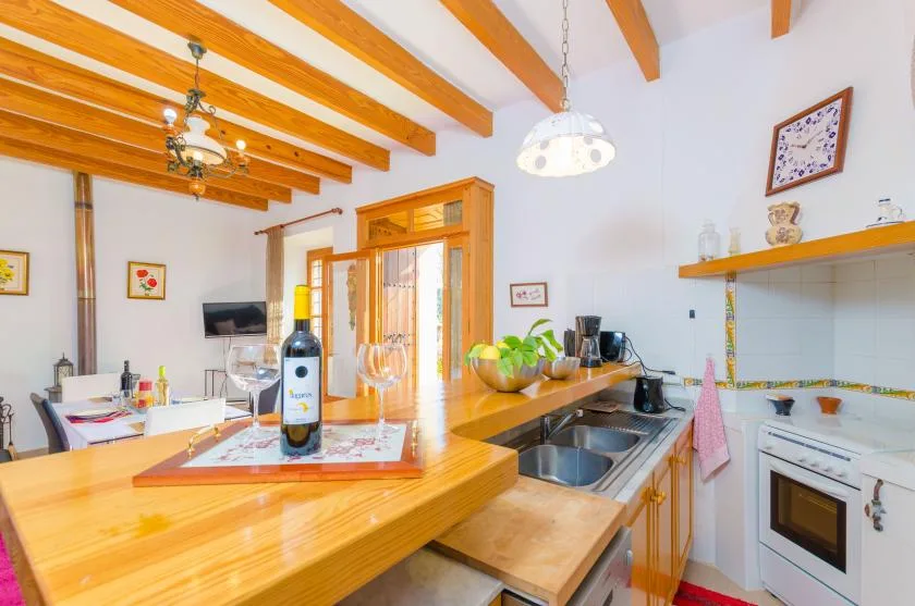 A bright kitchen with a wooden counter, sink, and cooking area.