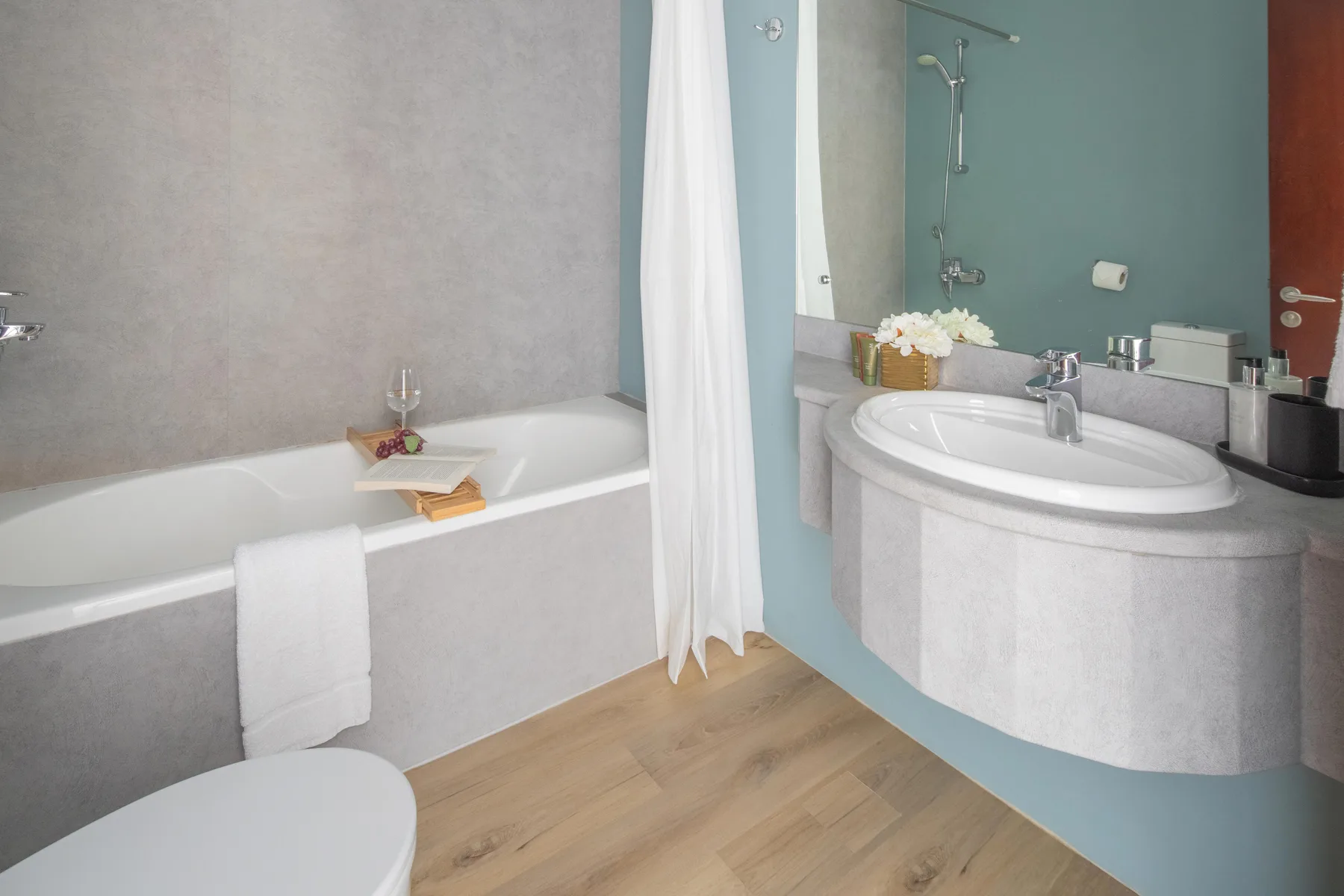 Un baño con bañera, lavabo y ducha.