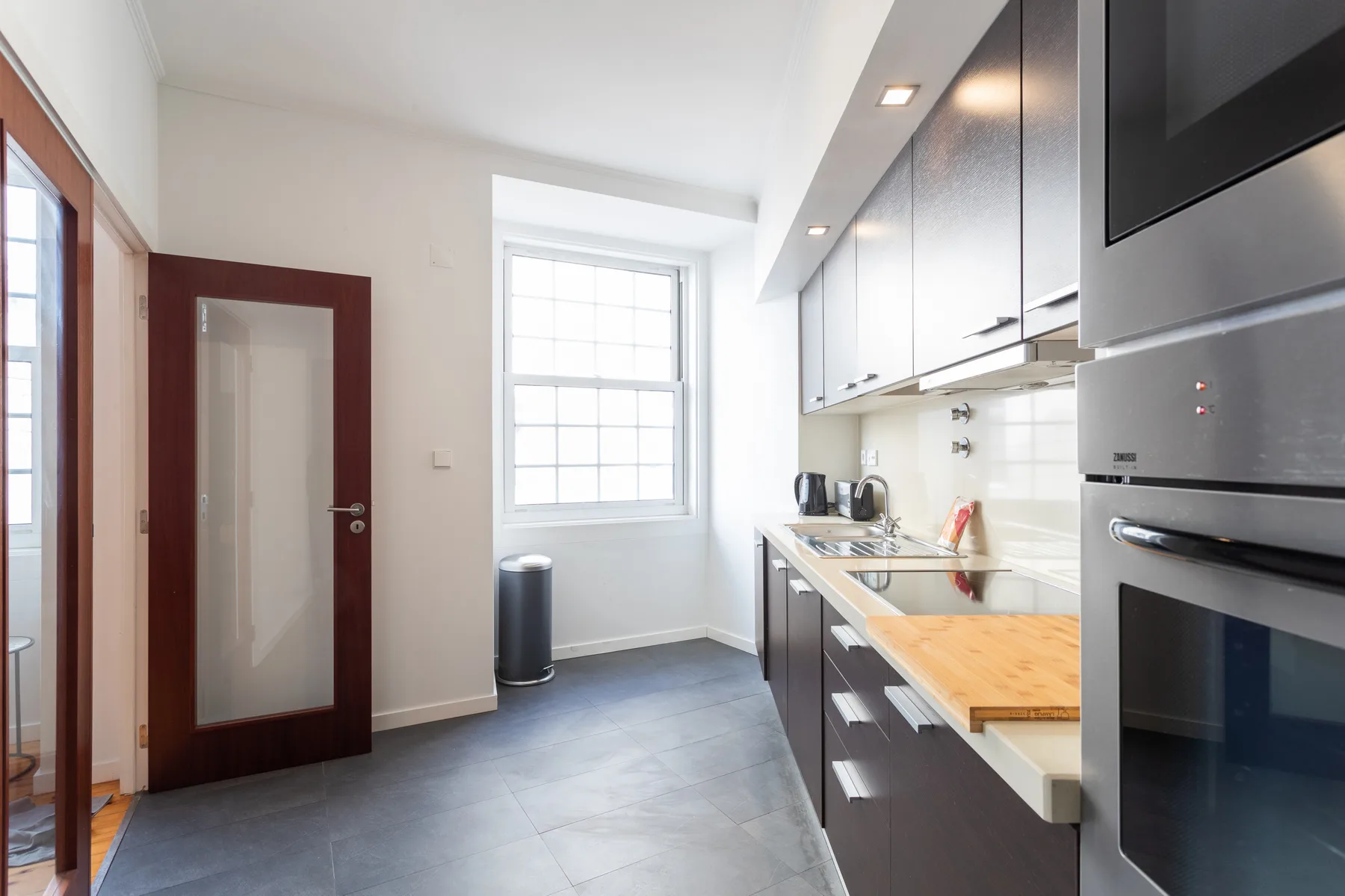 A modern kitchen with a countertop, sink, and built-in appliances.