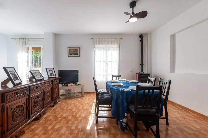 Un comedor con una mesa cubierta de azul y sillas de madera oscura.