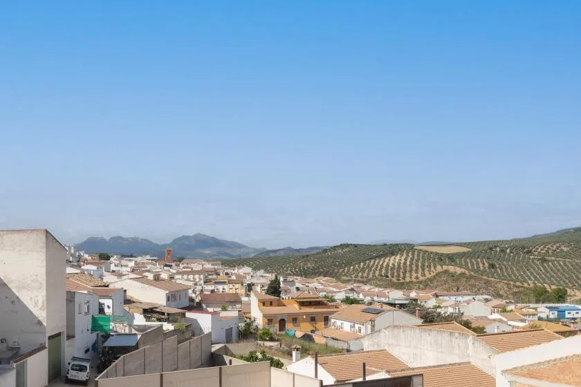 Un pueblo se extiende por colinas bajas bajo un cielo azul despejado.