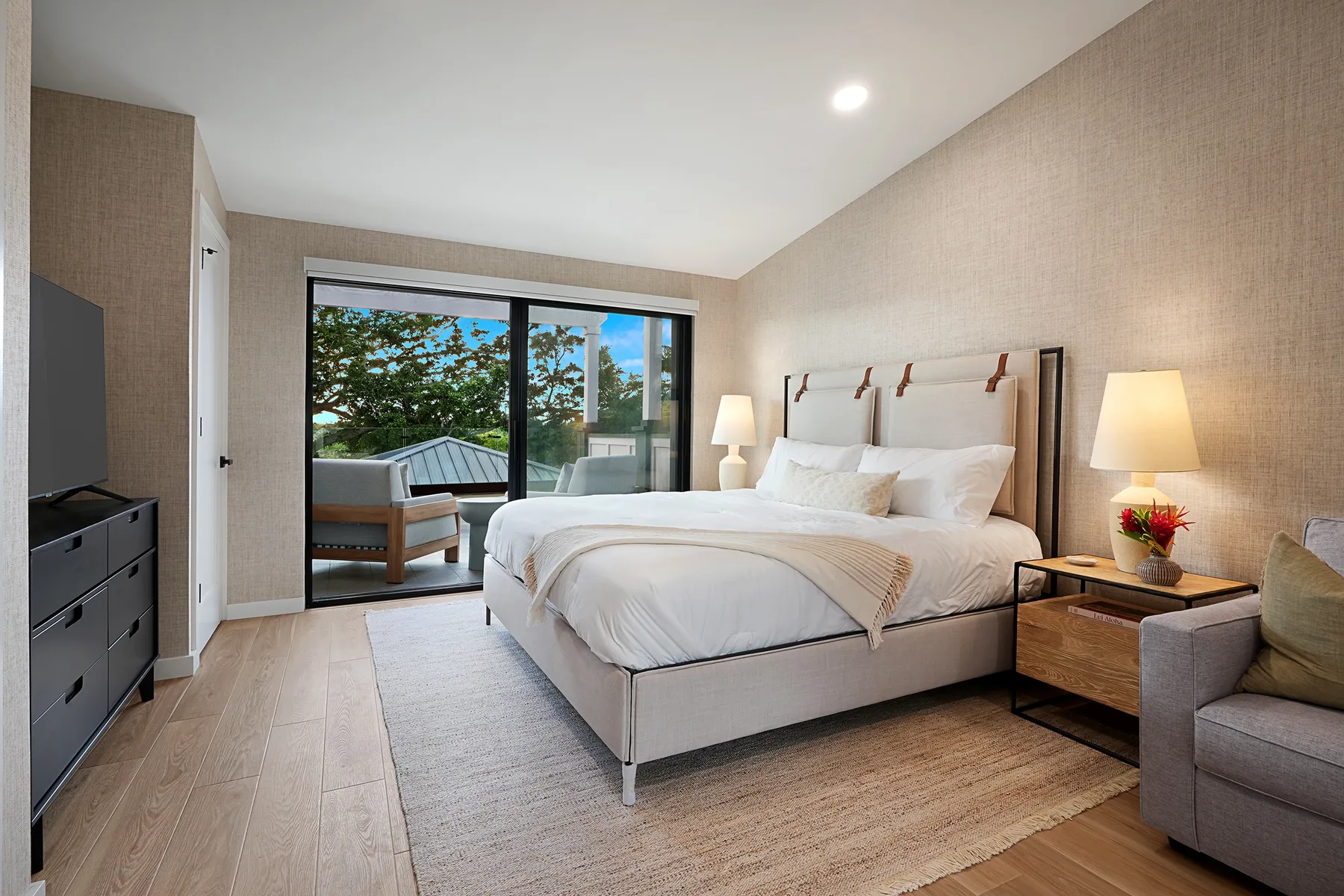A bright bedroom with a large bed and glass doors opening onto a balcony.
