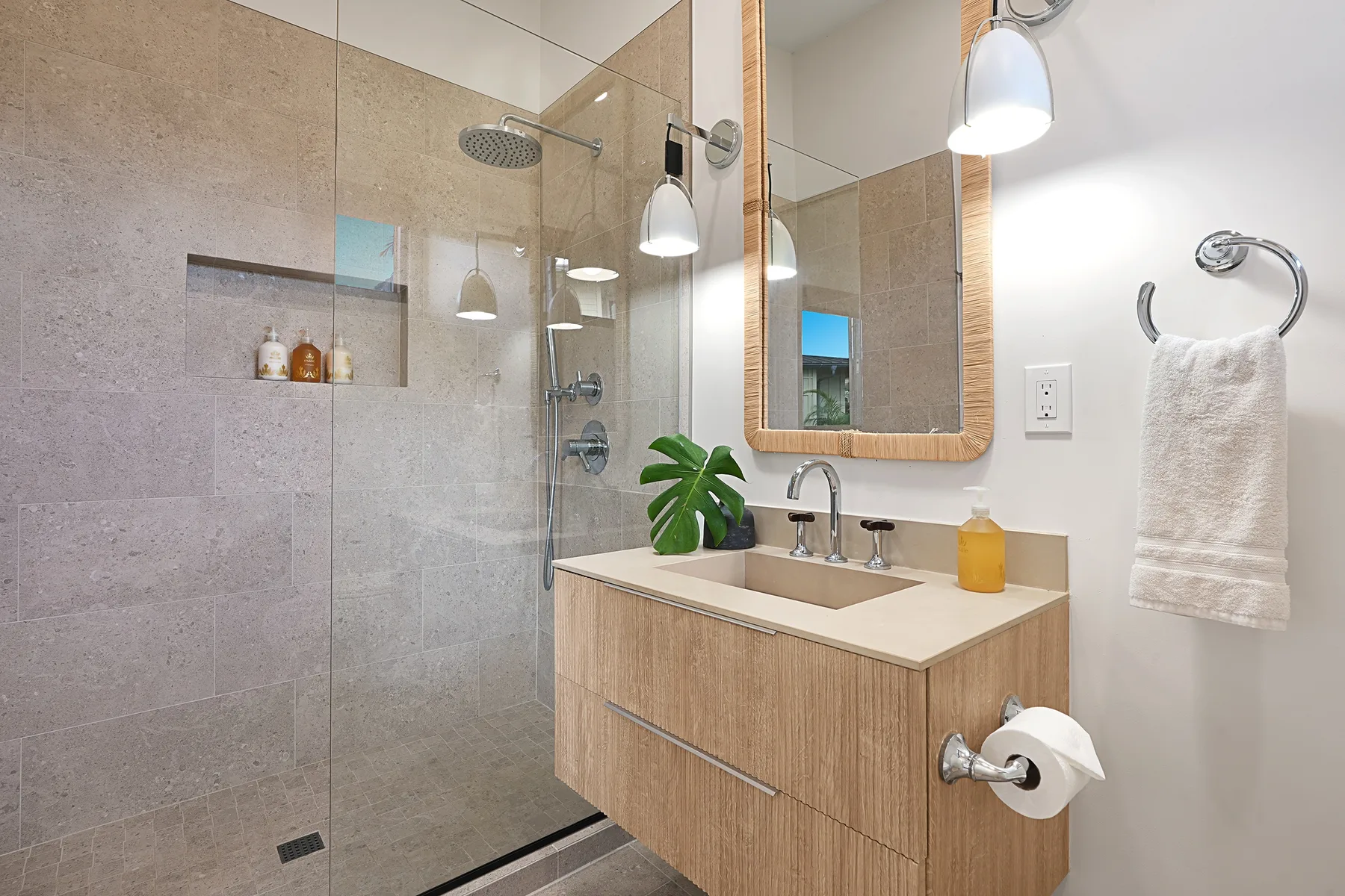 A modern bathroom with a glass-enclosed shower and a wood vanity.