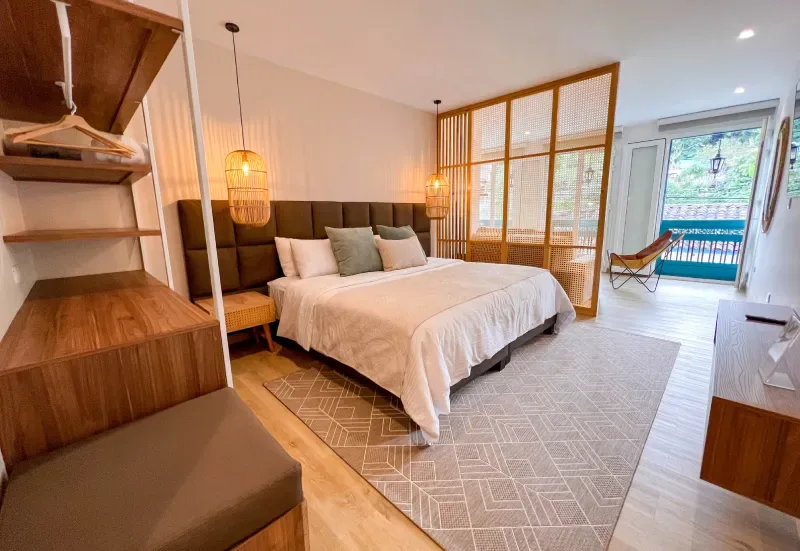 Dormitorio de la Suite Santa Isabel con una cama grande y vista al exterior.