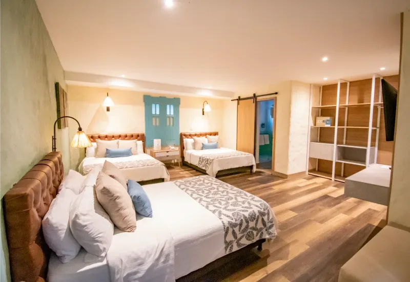 Habitación doble con camas grandes e iluminación cálida.