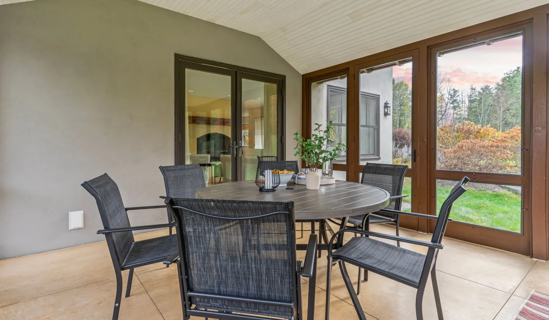 Un comedor con una mesa y sillas junto a grandes ventanas.