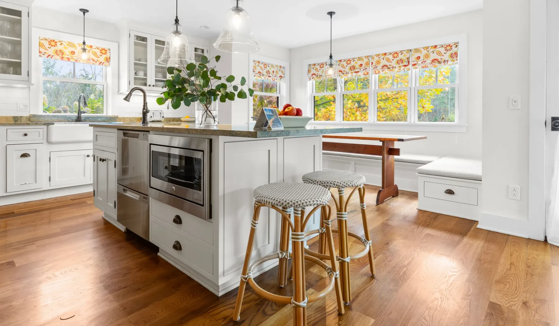 Una cocina luminosa con una isla central y cortinas de colores.