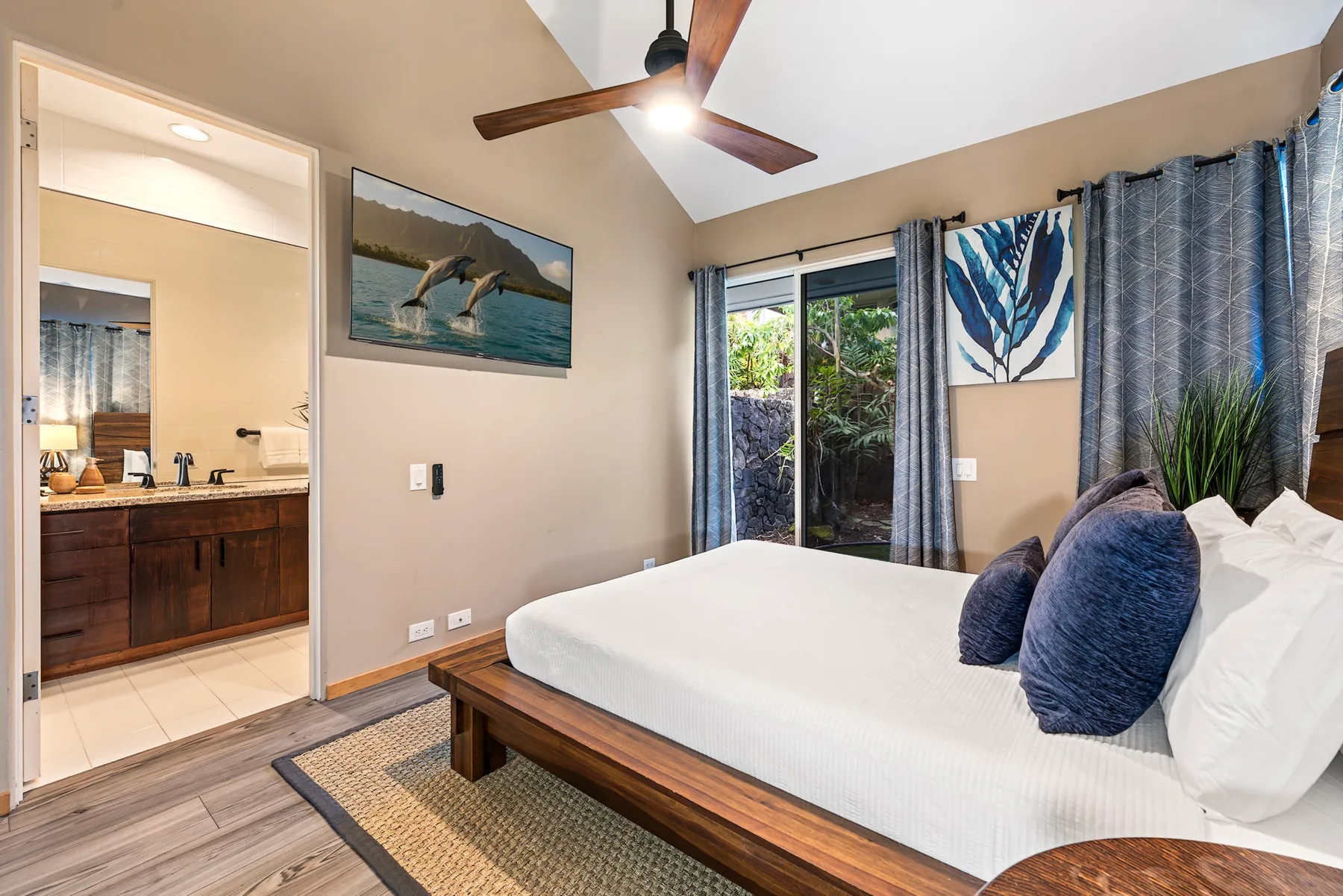 Un dormitorio con una cama junto a puertas corredizas de vidrio y cortinas azules.