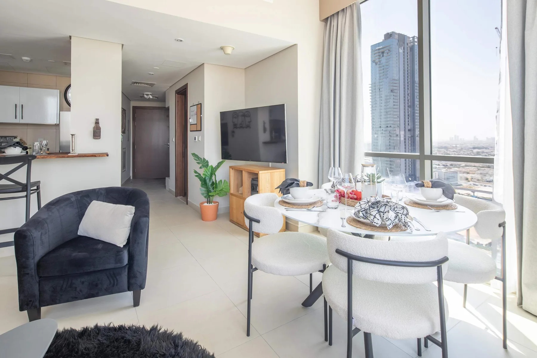 Una luminosa sala-comedor de planta abierta con una mesa puesta junto a grandes ventanales.