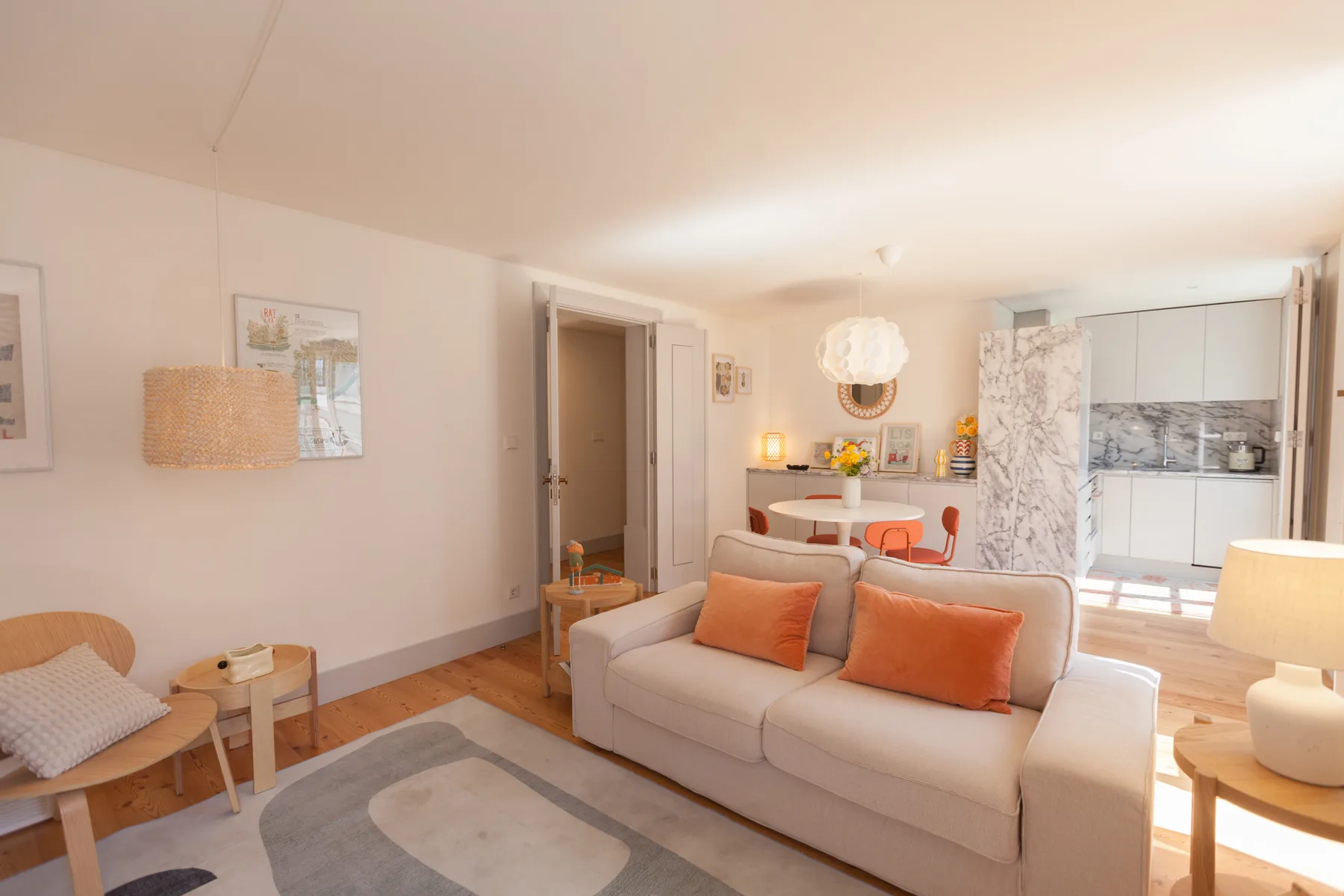 A bright living room with a sofa and a dining area in the background.