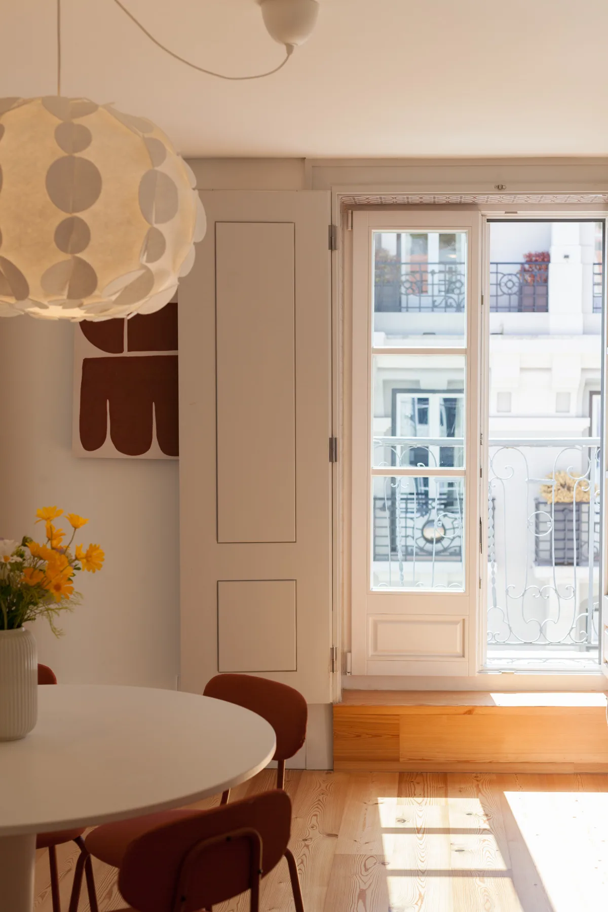 A bright dining area with a round table beside a large window.