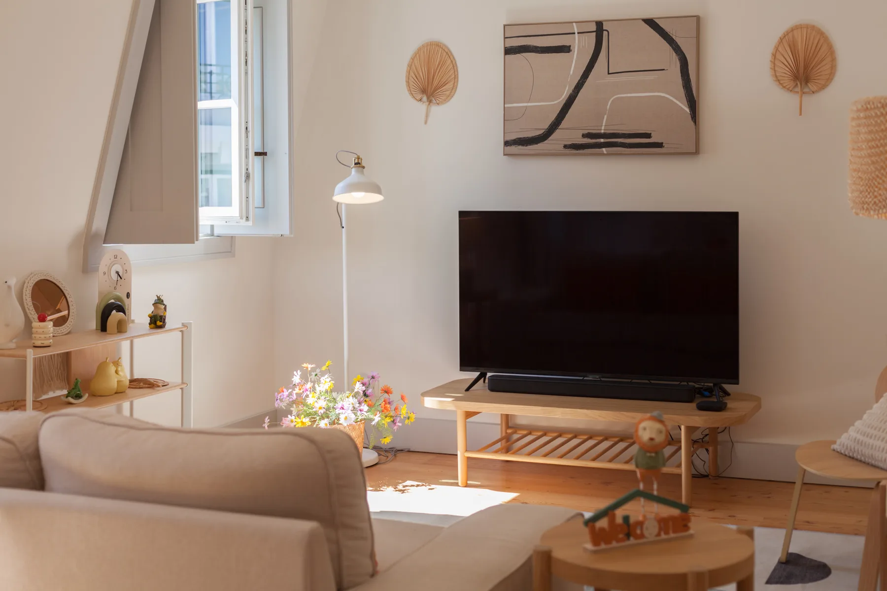 Living room with a television, seating, and decorative wall art.