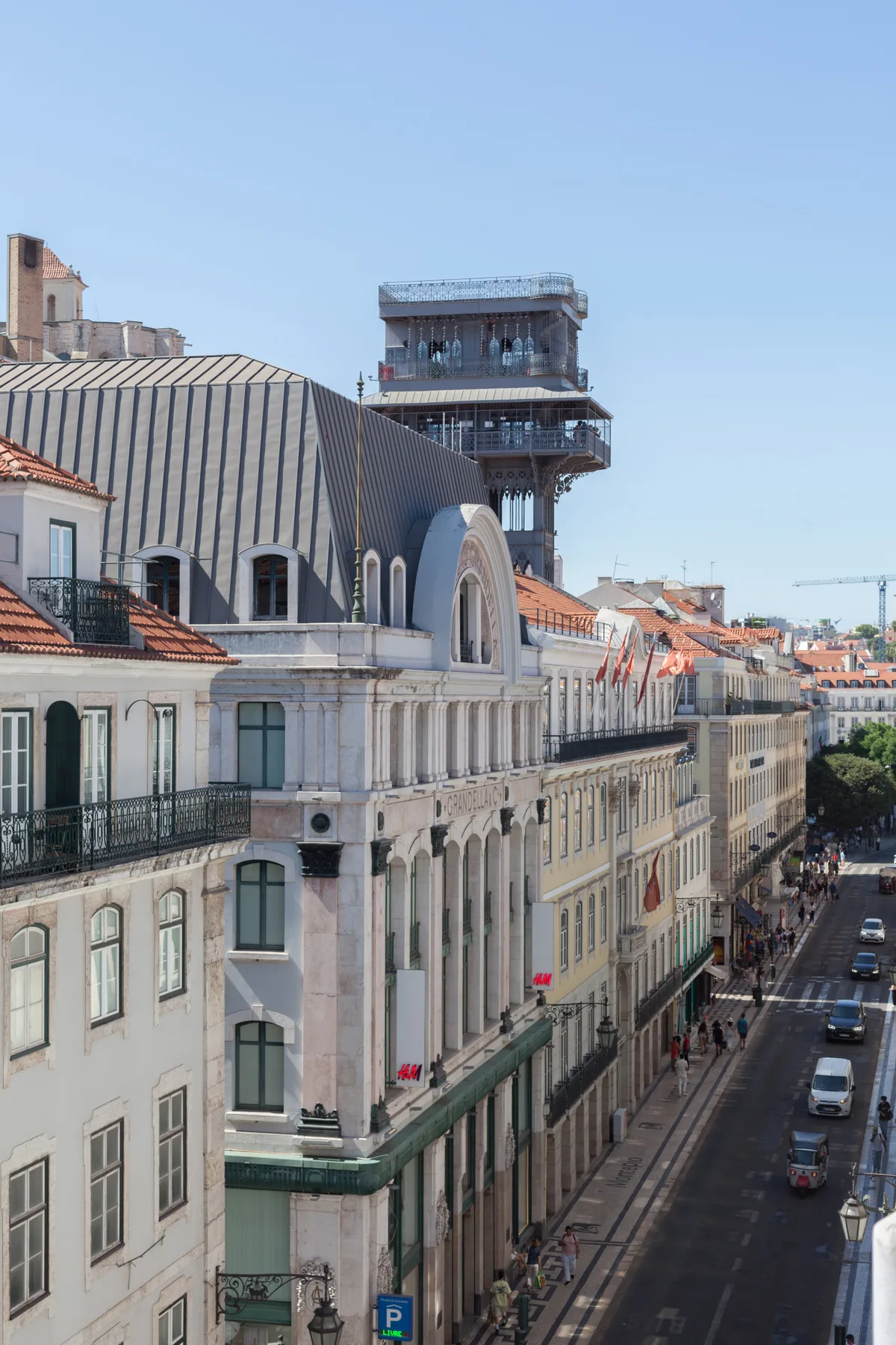 A city street lined with historic buildings, with a modern tower rising behind them.