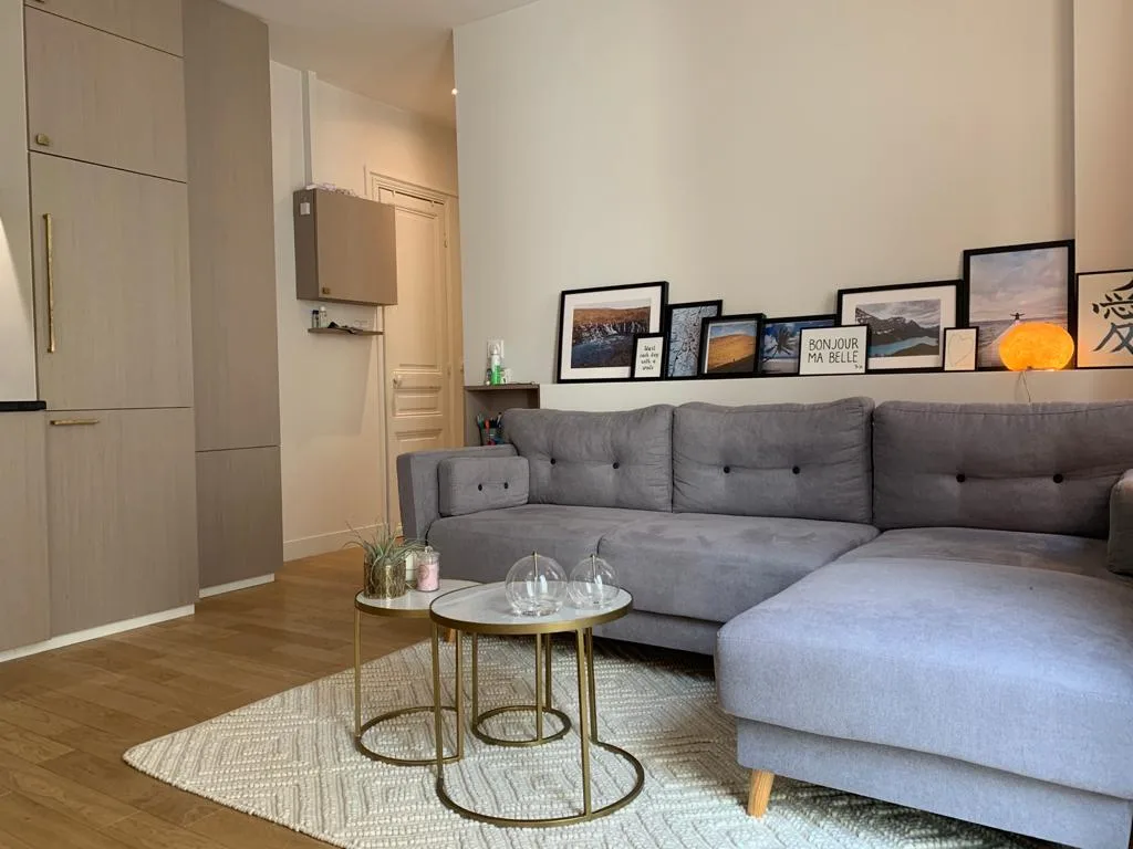 A living room with a gray sectional sofa and round glass coffee tables.