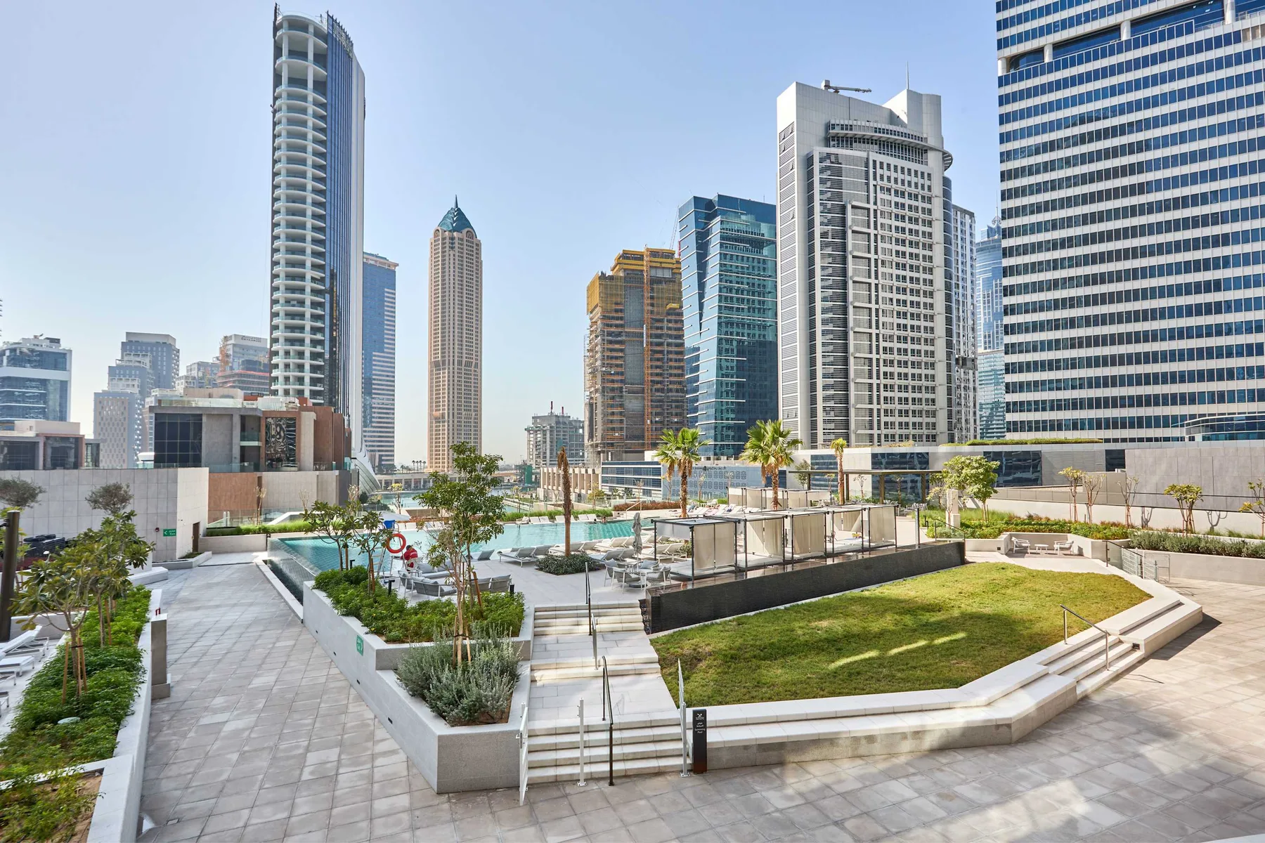 Una terraza ajardinada en la azotea ofrece vistas de varios edificios altos.