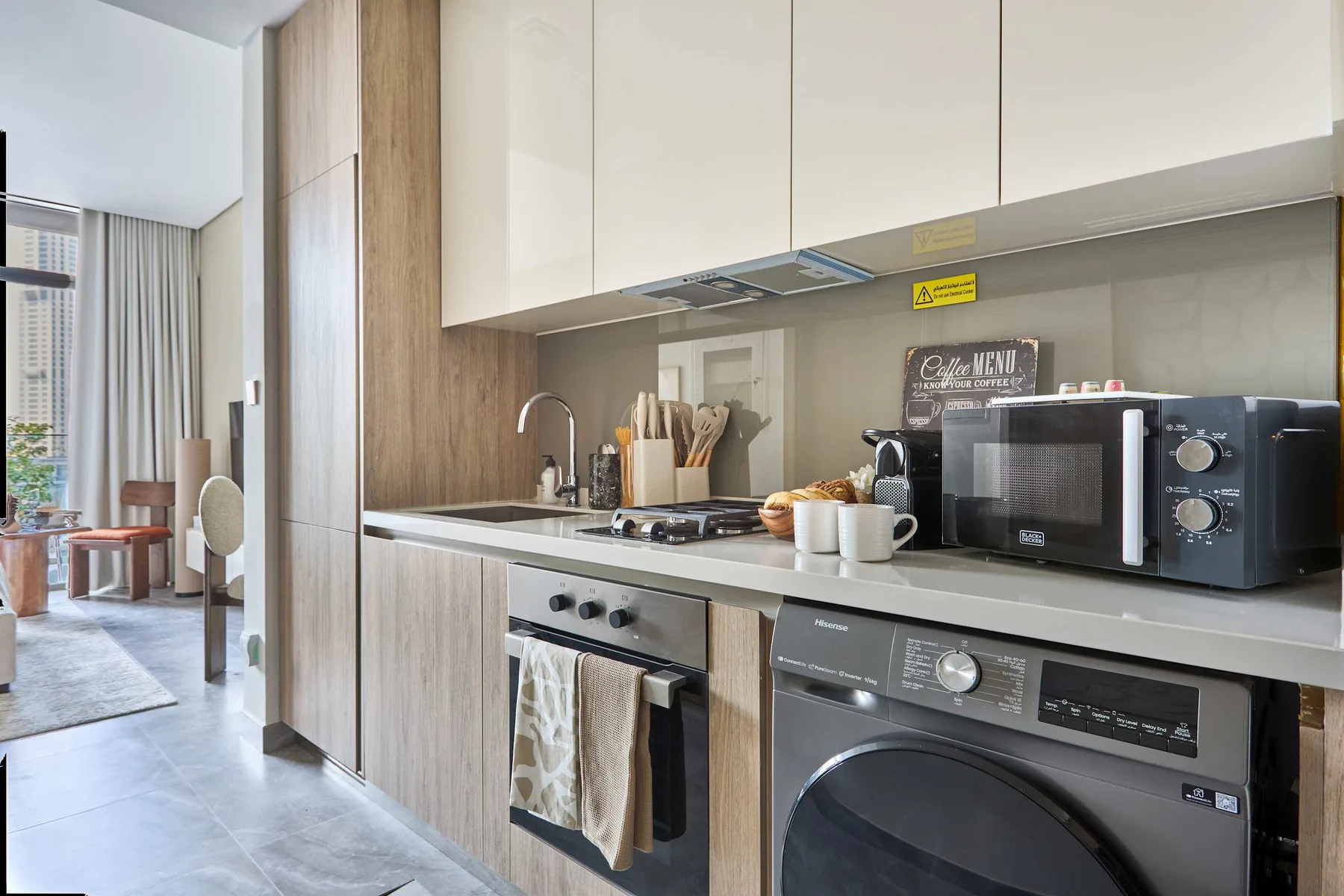 Una cocina moderna con placa de cocción, horno, microondas y lavadora de carga frontal.