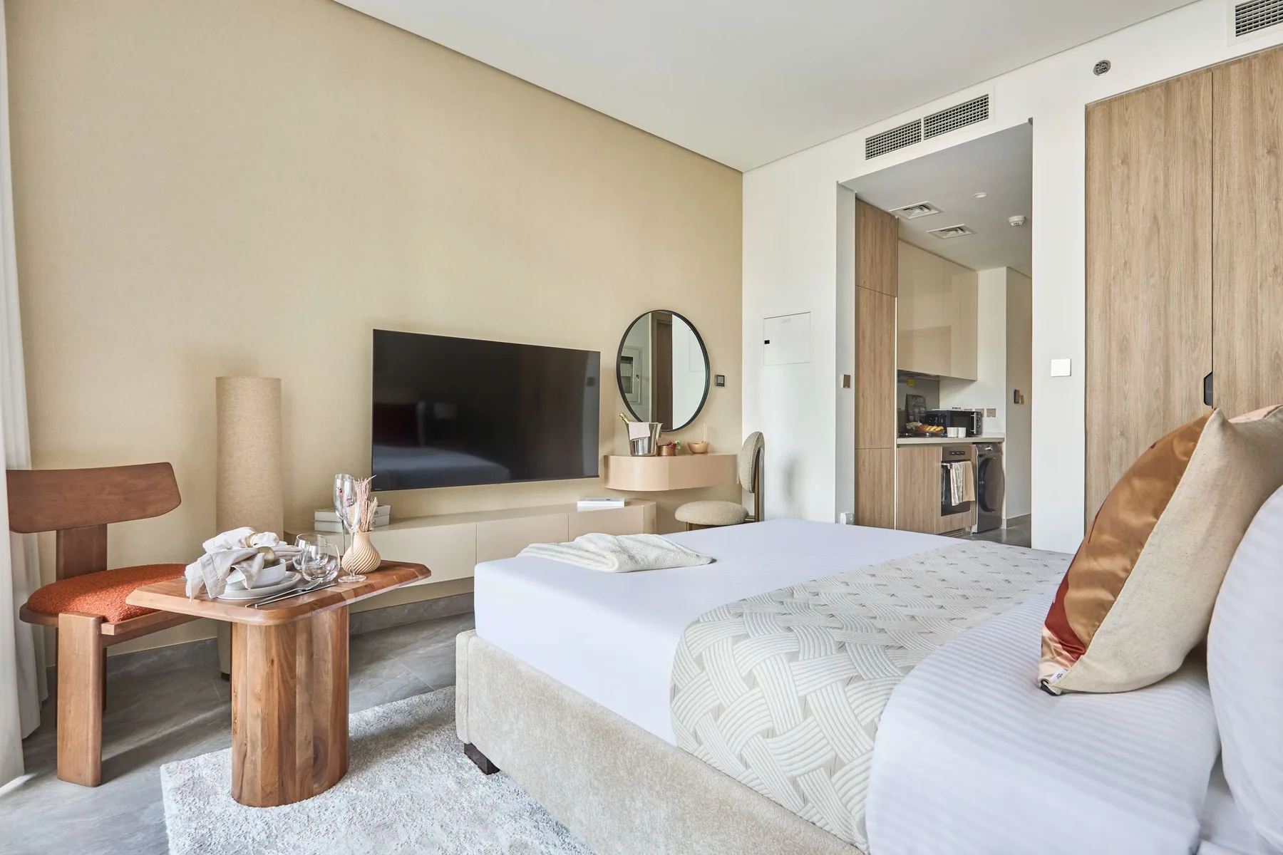 Un dormitorio con una cama, un televisor y una pequeña zona para sentarse.