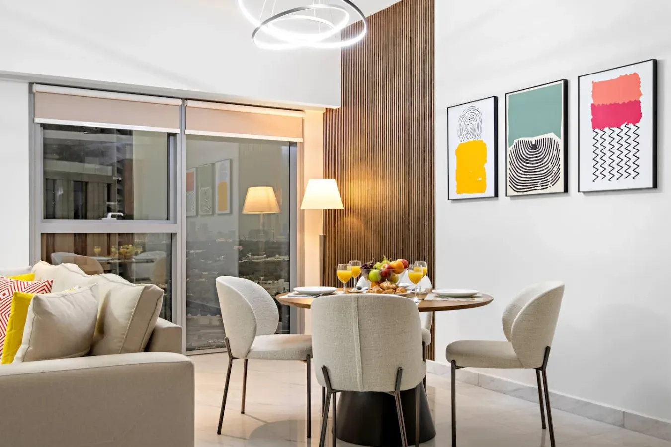 Un comedor con una mesa redonda y asientos tapizados junto a una ventana amplia.