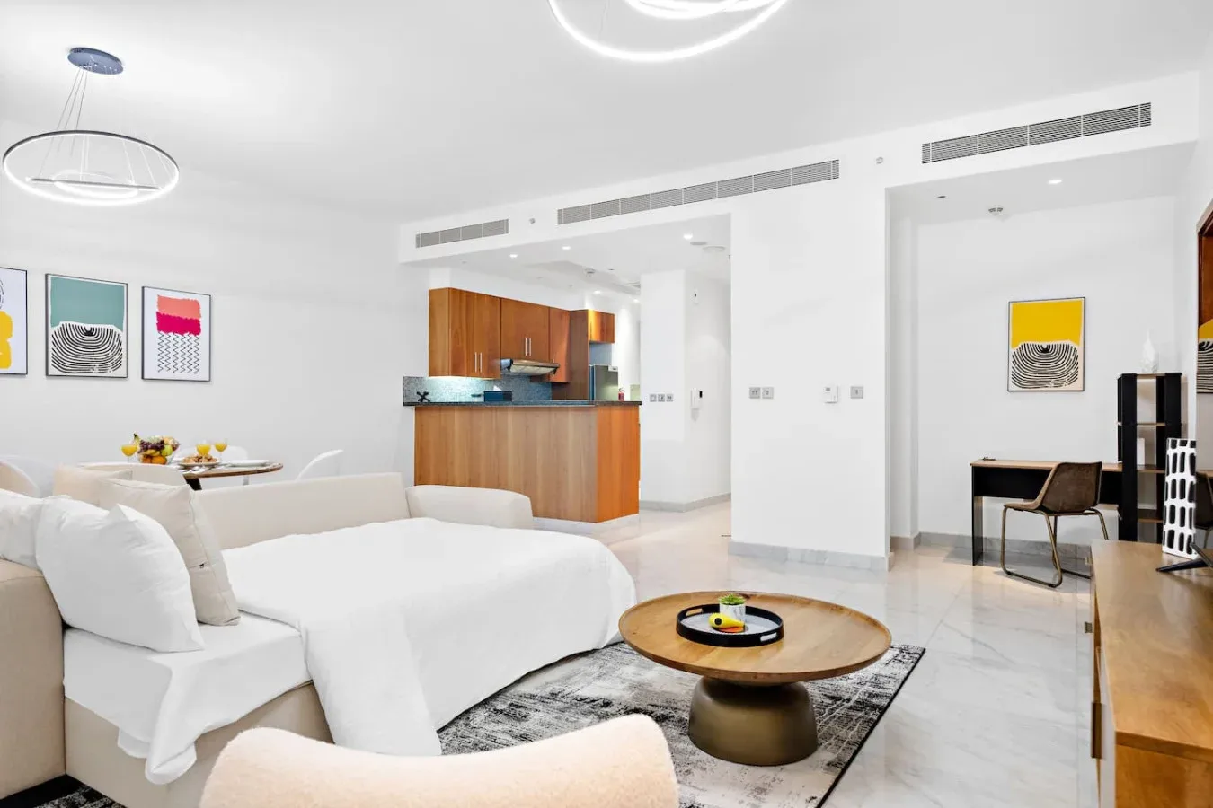 Una luminosa sala de estar de planta abierta con mesa de comedor y barra de cocina.